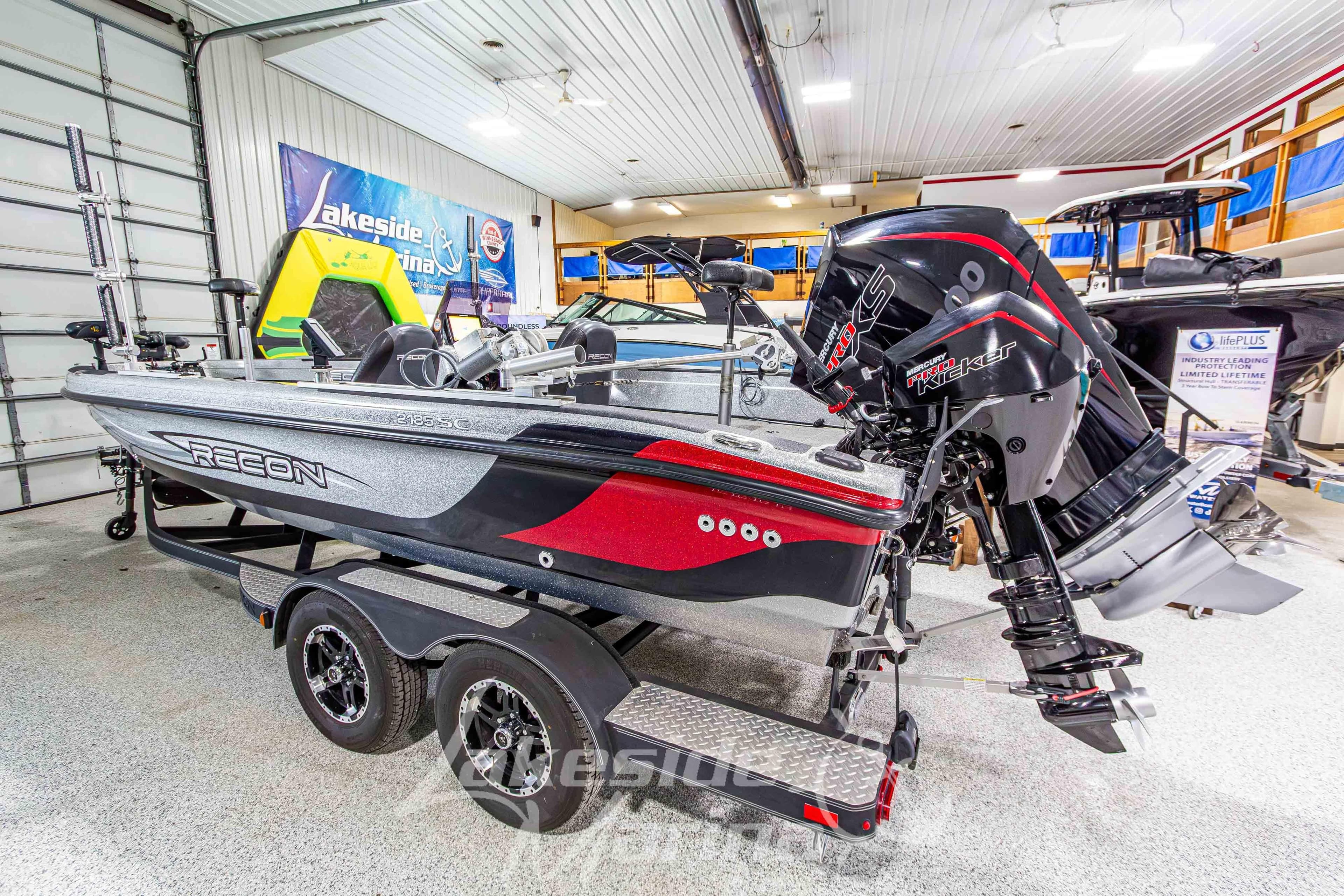 2019 Recon 2185 SC boat with powerful outboard motor in showroom display.