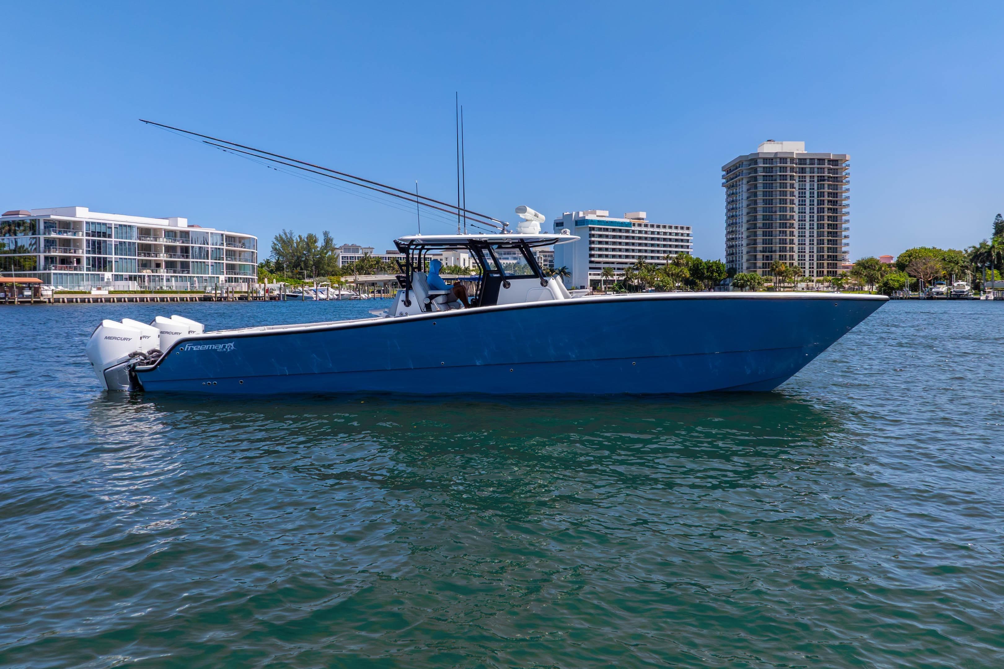 2019 Freeman 42LR boat on water, cityscape background, clear blue sky.