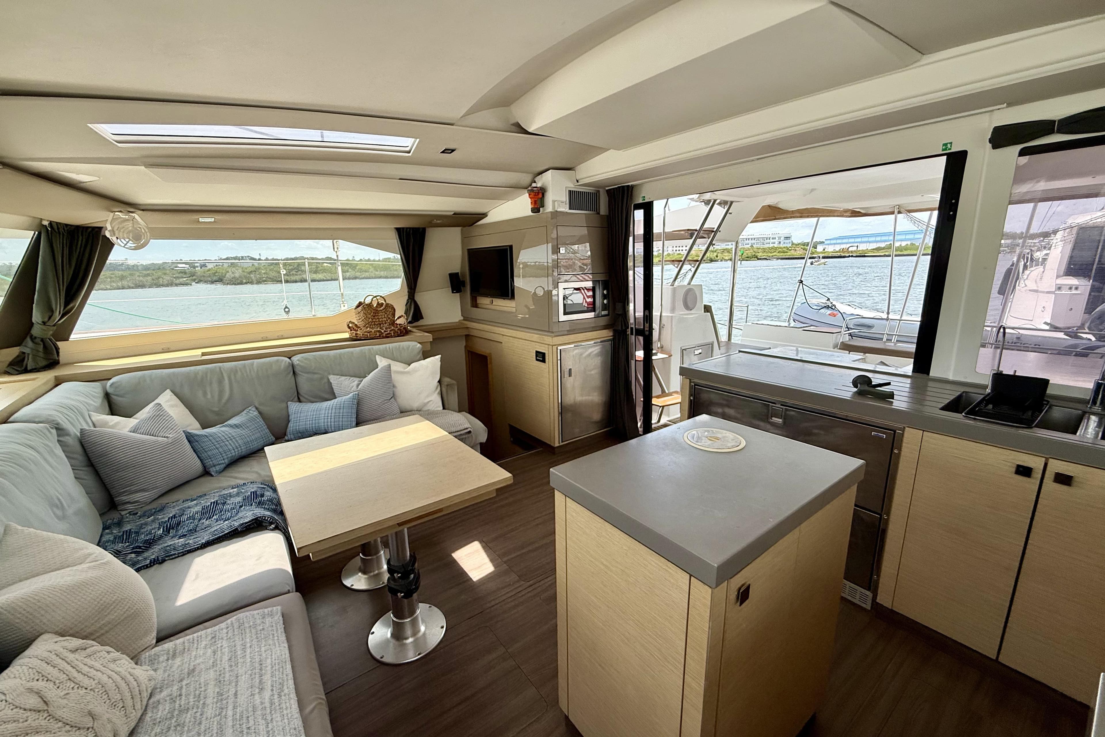 Luxurious interior of 2018 Fountaine Pajot Saona 47 catamaran with modern furnishings and scenic views.