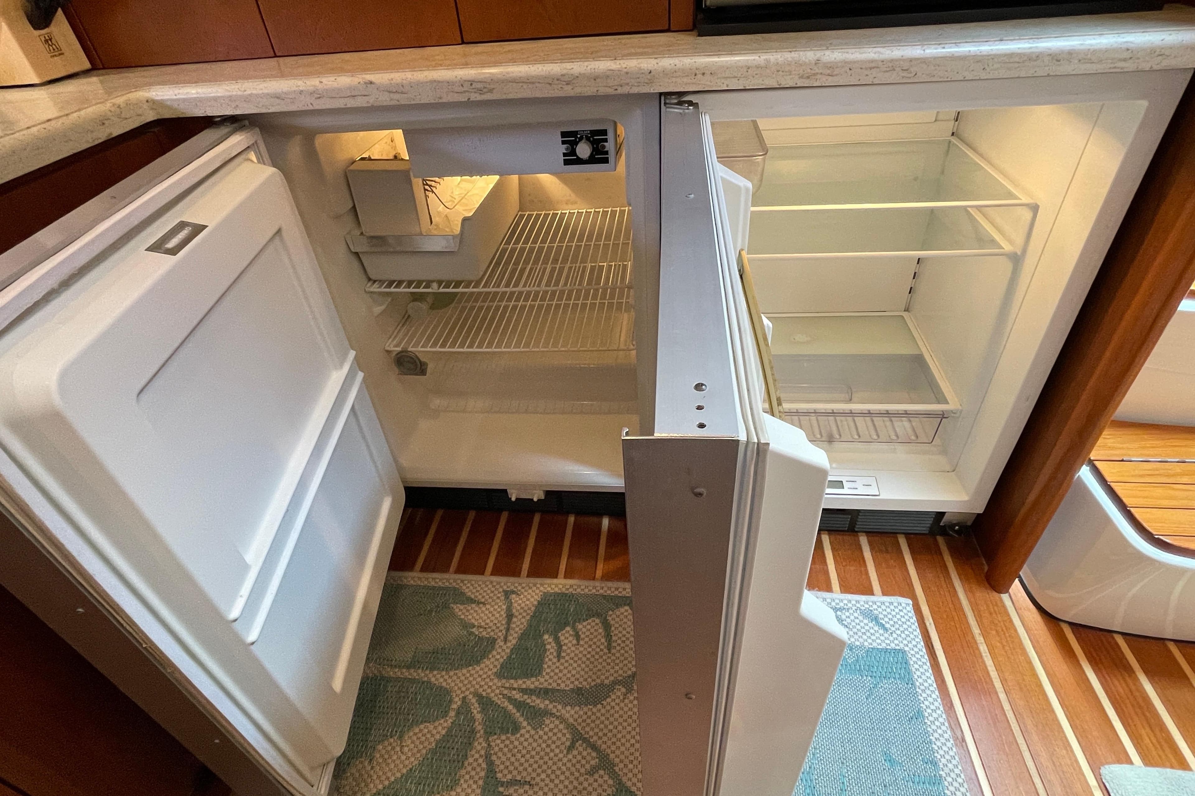Open refrigerator in 2009 Tiara Yachts 4200 Open, showcasing interior shelves and wooden flooring.