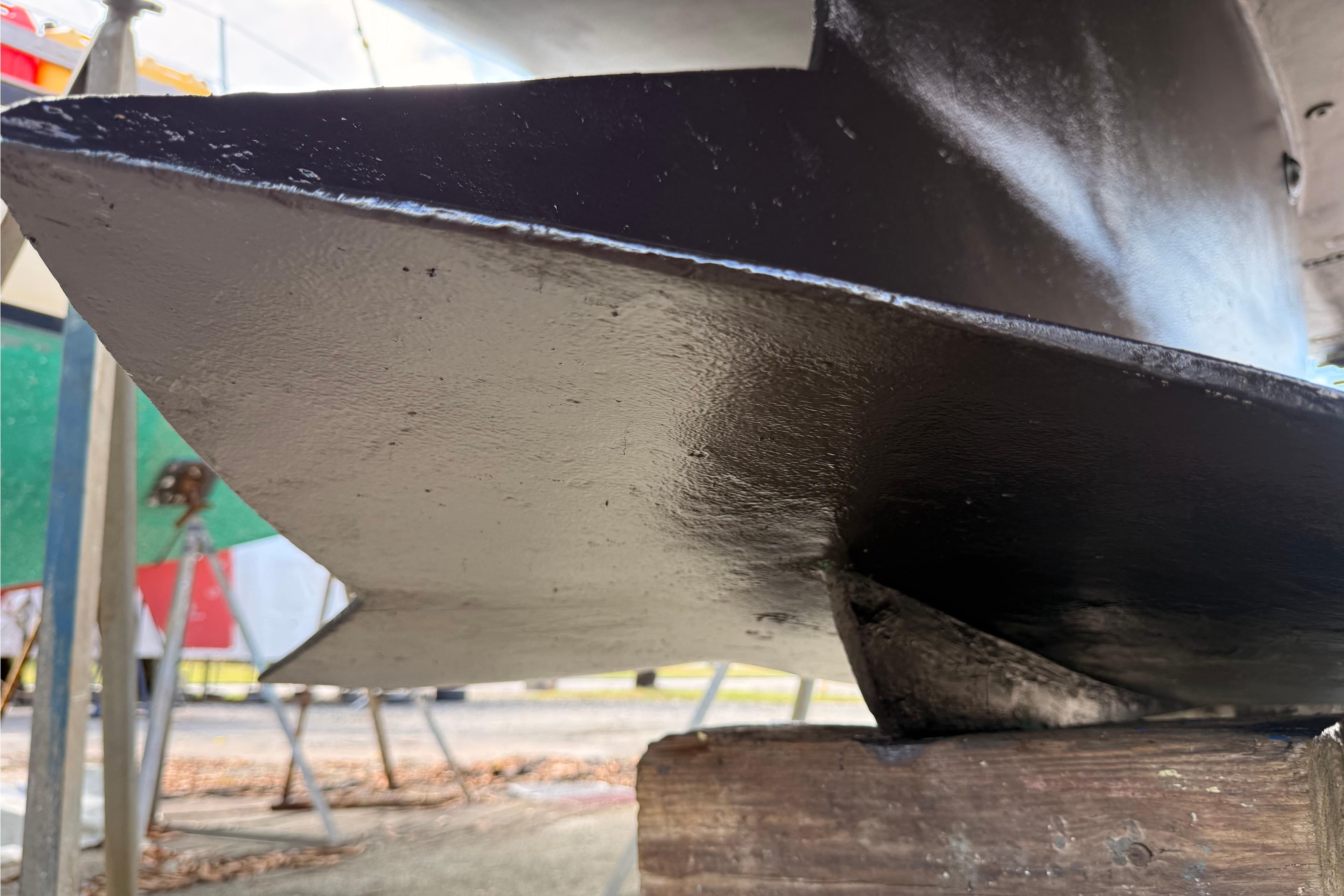 Close-up of a 1996 Hunter 376 sailboat keel on a wooden block.