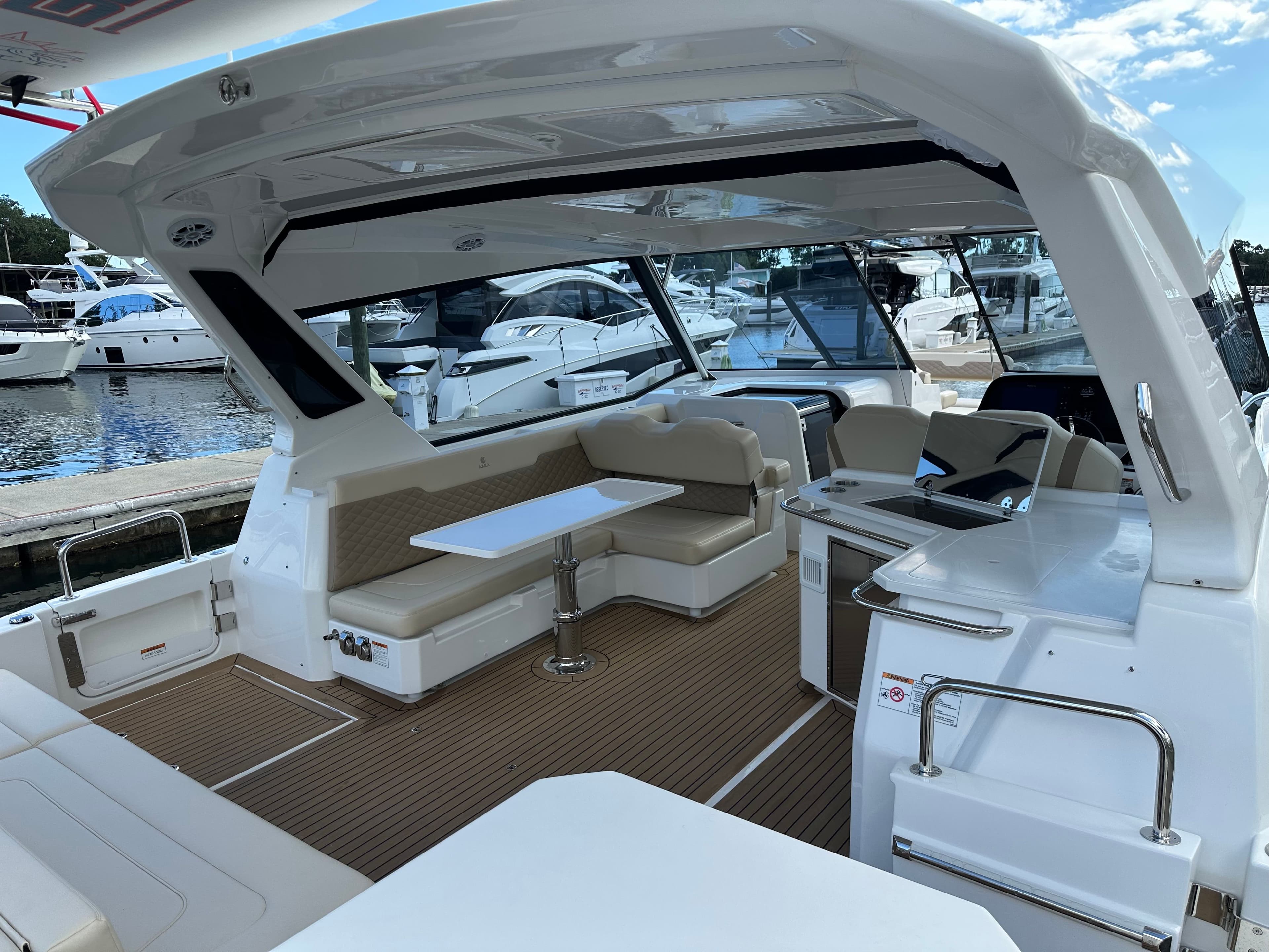 2025 Aquila 36 Sport yacht interior with seating and table, docked at marina.
