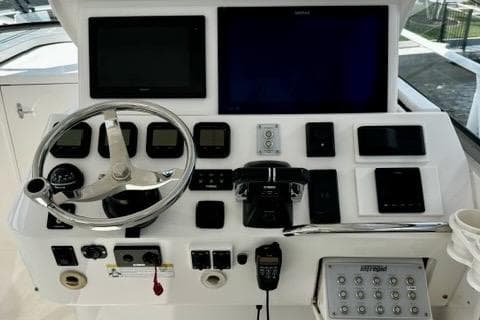 Control panel of a 2013 Intrepid 430 Sport Yacht with steering wheel and navigation screens.