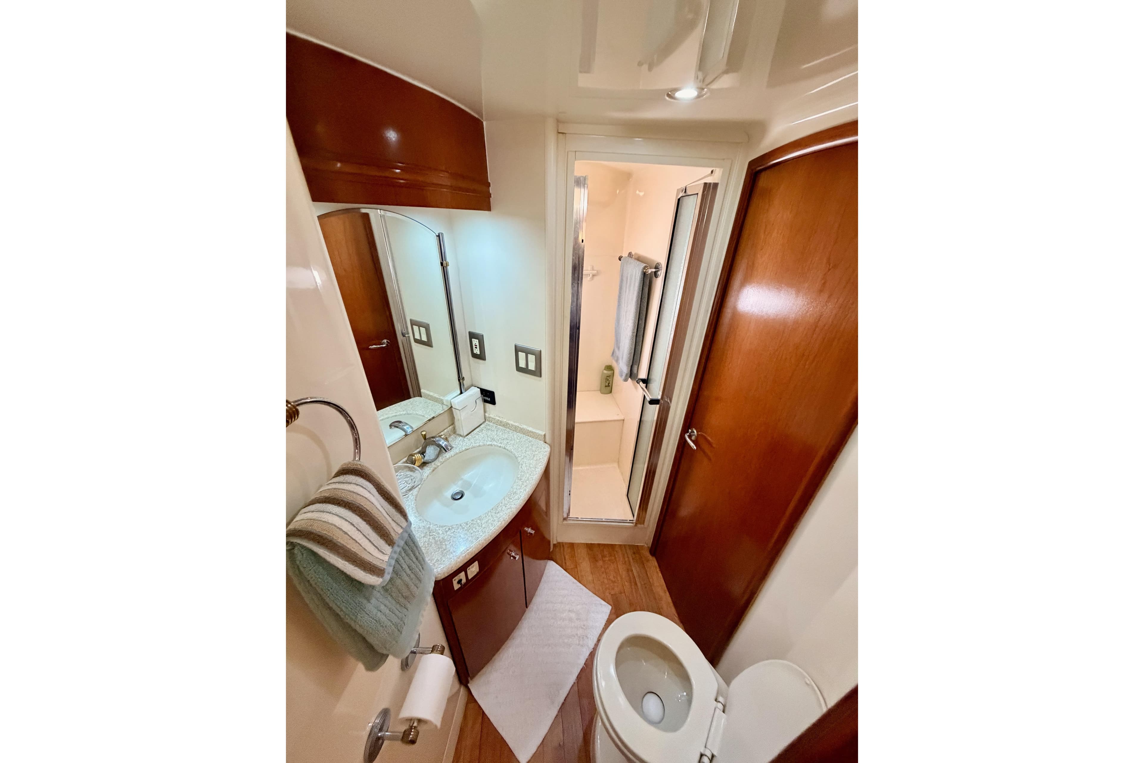 Bathroom interior of 1999 Carver 530 Voyager Pilothouse yacht, featuring sink, toilet, and shower.
