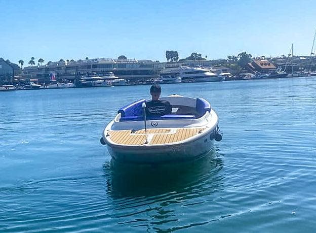 2023 Vision Marine Technologies Fantail 217 boat on calm water, with a person onboard.