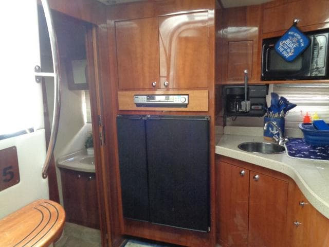 2003 Regal Commodore 3860 yacht kitchen with wood cabinets, sink, and appliances.