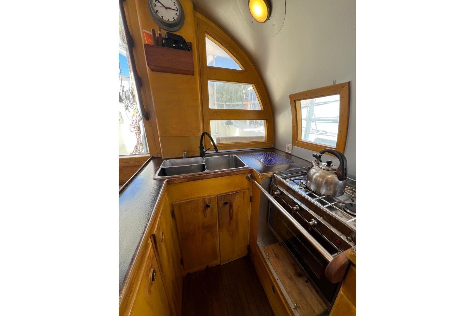 Compact wooden kitchen with stove, sink, and kettle in a 1998 Meta Custom model.