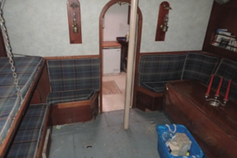 Interior of 1997 Hike Metal Products 67-foot ketch with plaid seating and wooden accents.