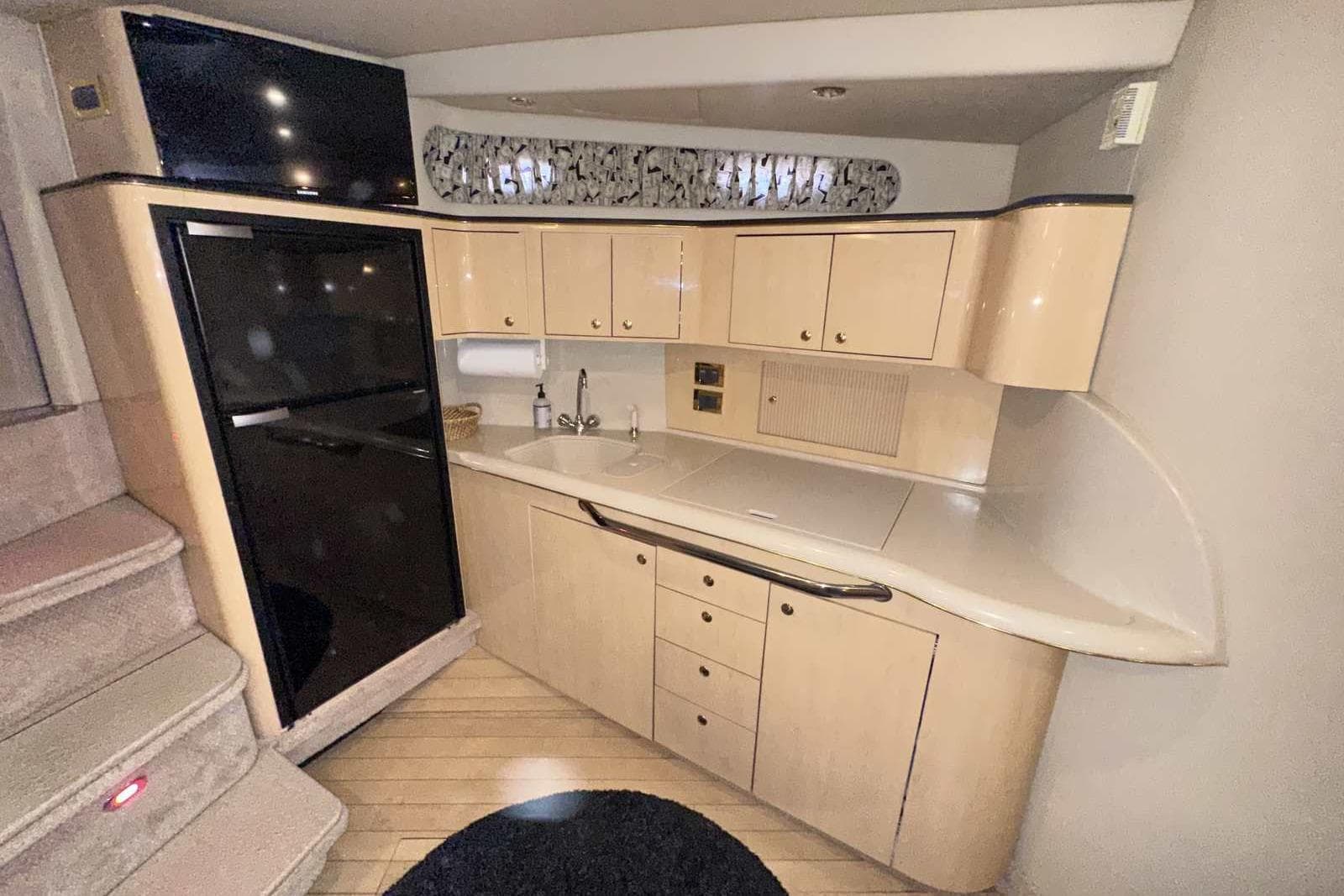 2000 Sea Ray 410 Sundancer yacht interior kitchen with cabinets and sink.