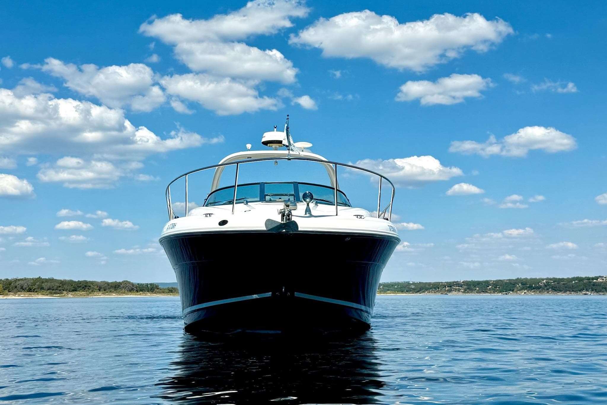 2005 Sea Ray 340 Sundancer yacht on calm water under a blue sky with clouds.