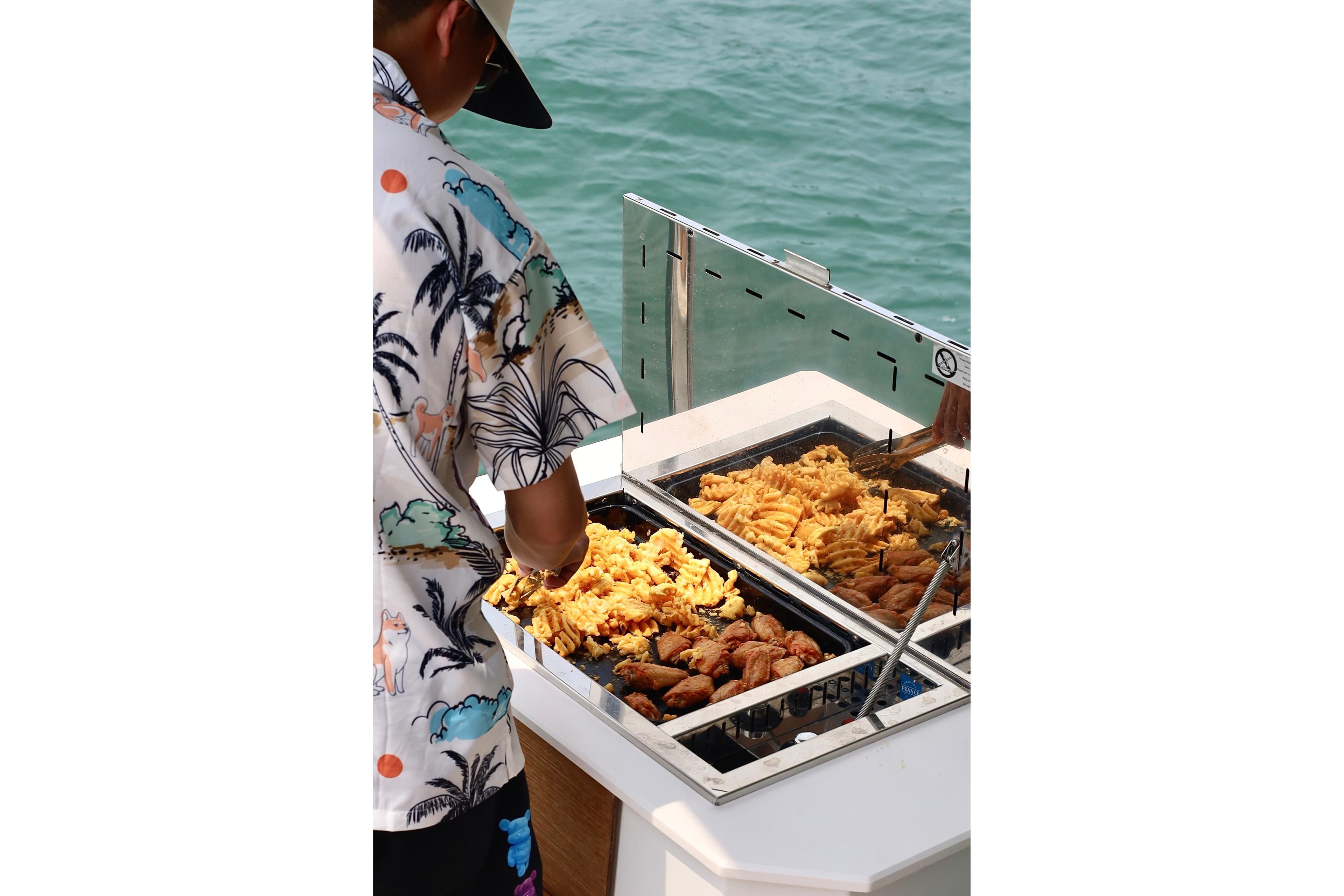 Person grilling food on a 2023 Fountaine Pajot Samana 59 yacht.