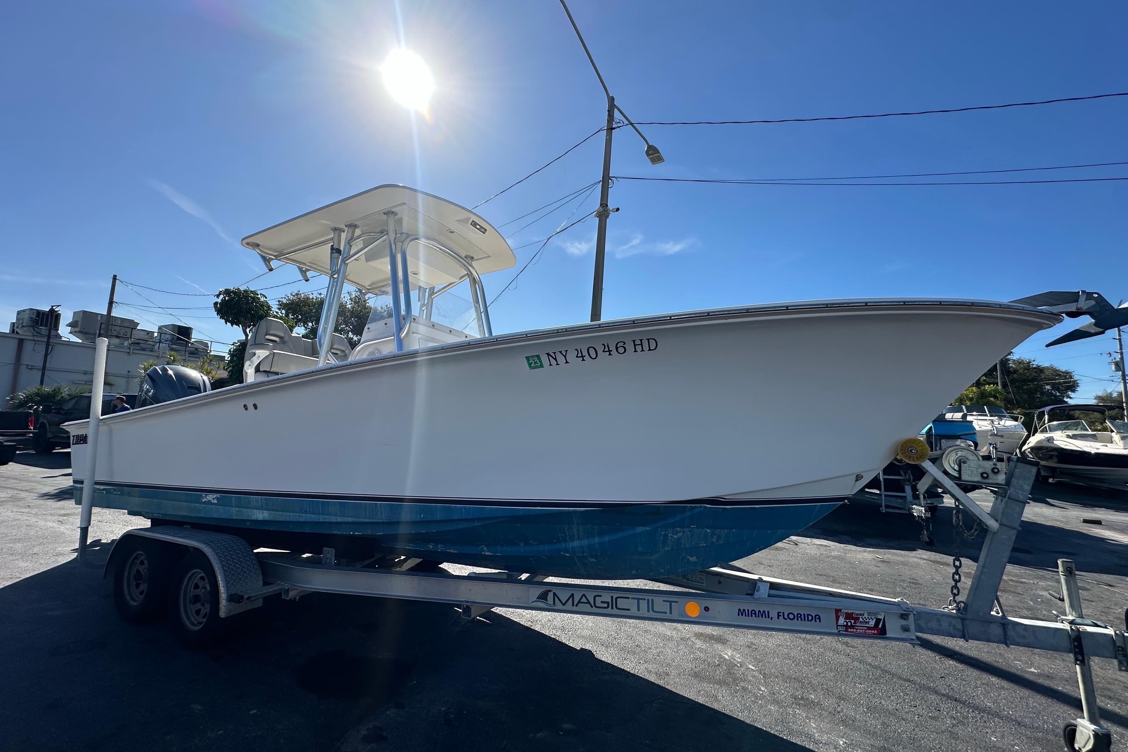 2005 Topaz 24 Silverhawk boat on trailer under bright sun.