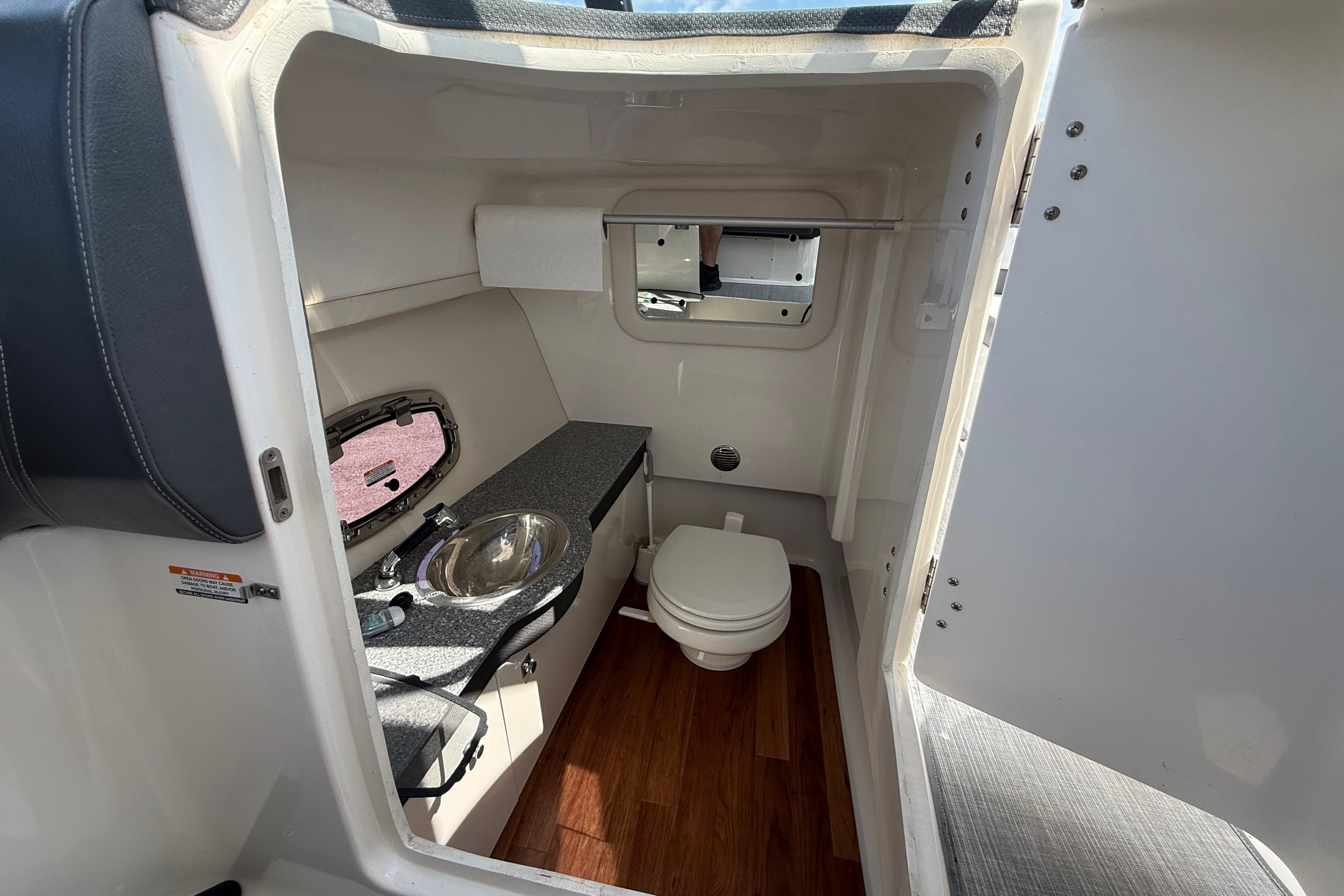 Interior of 2016 Chaparral 307 SSX boat bathroom with sink and toilet.