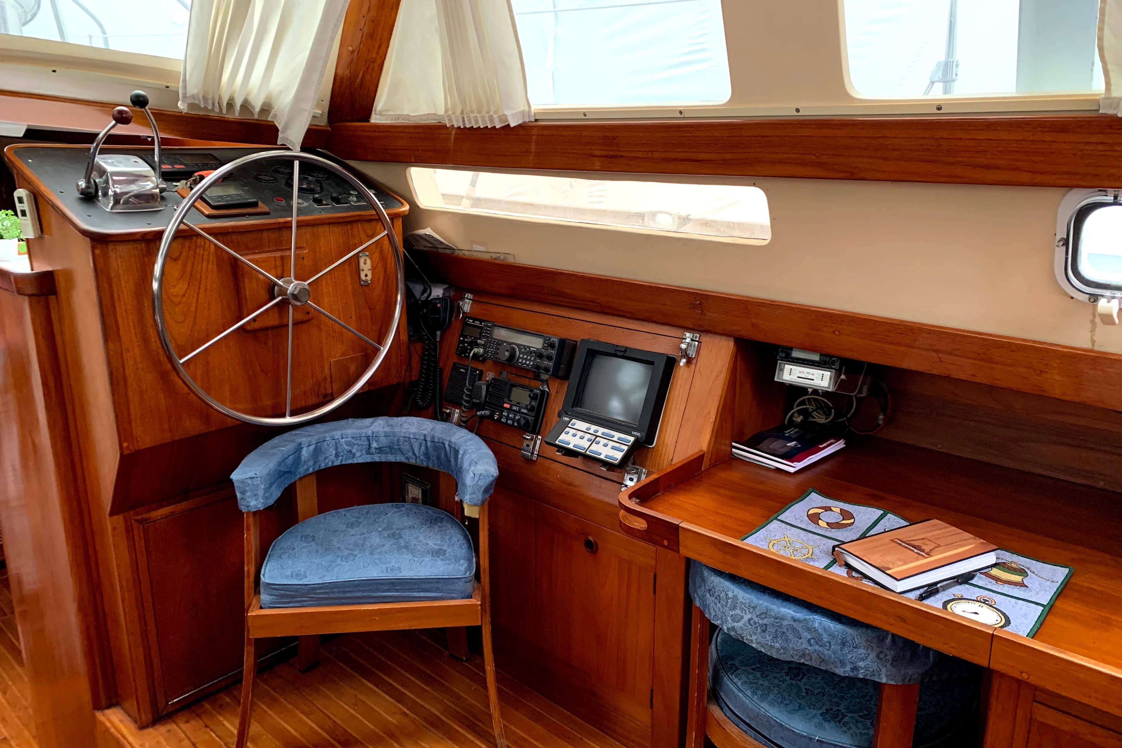 Interior of 1982 C&C Landfall 48 sailboat with wooden helm and navigation station.