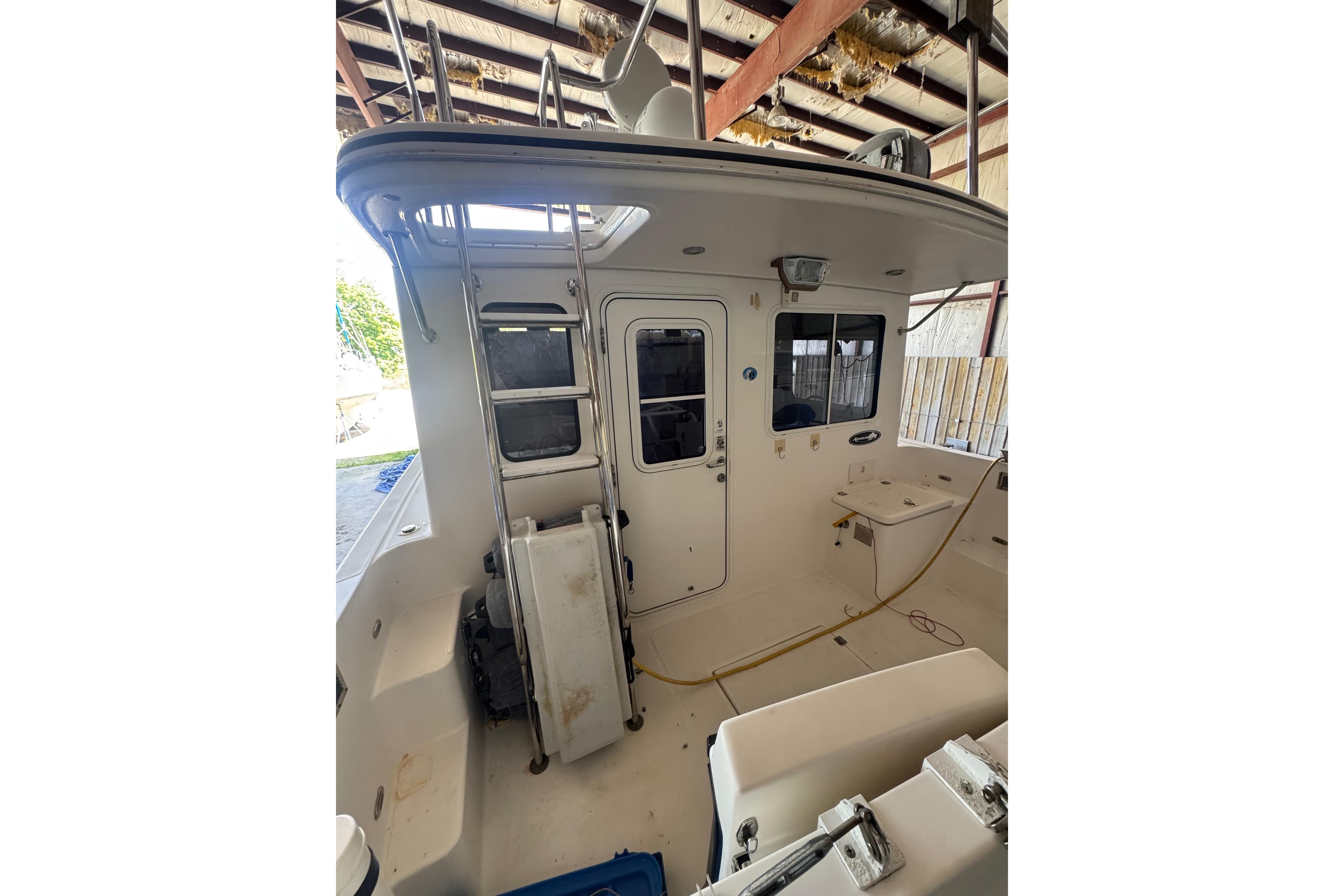 2005 American Tug 34 boat interior with ladder and windows in a covered area.
