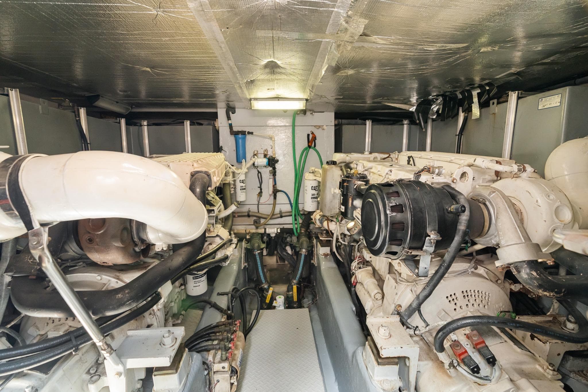 Engine room of 2001 Sea Ray 540 Cockpit Motor Yacht, showcasing dual engines and mechanical components.