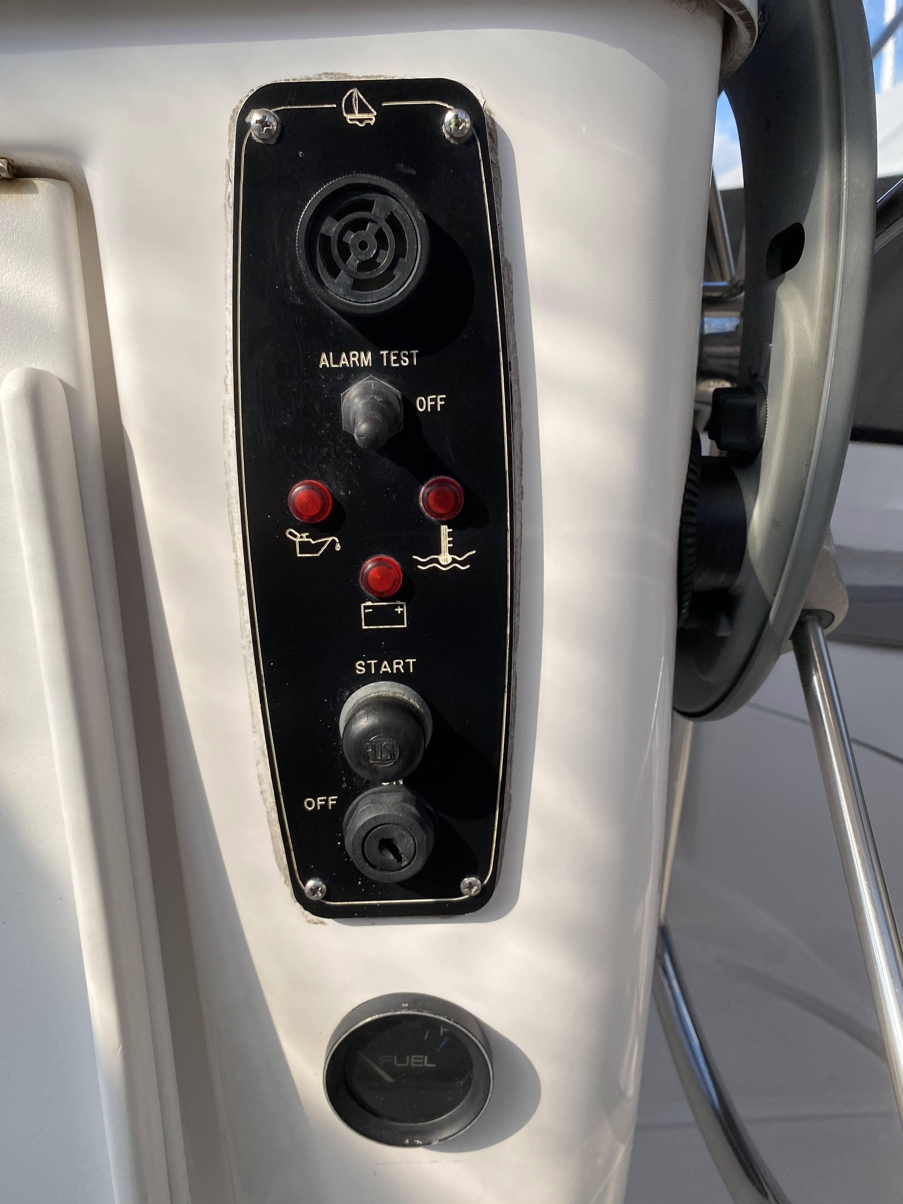 Control panel of a 2001 Hunter 320 sailboat with alarm and start switches.