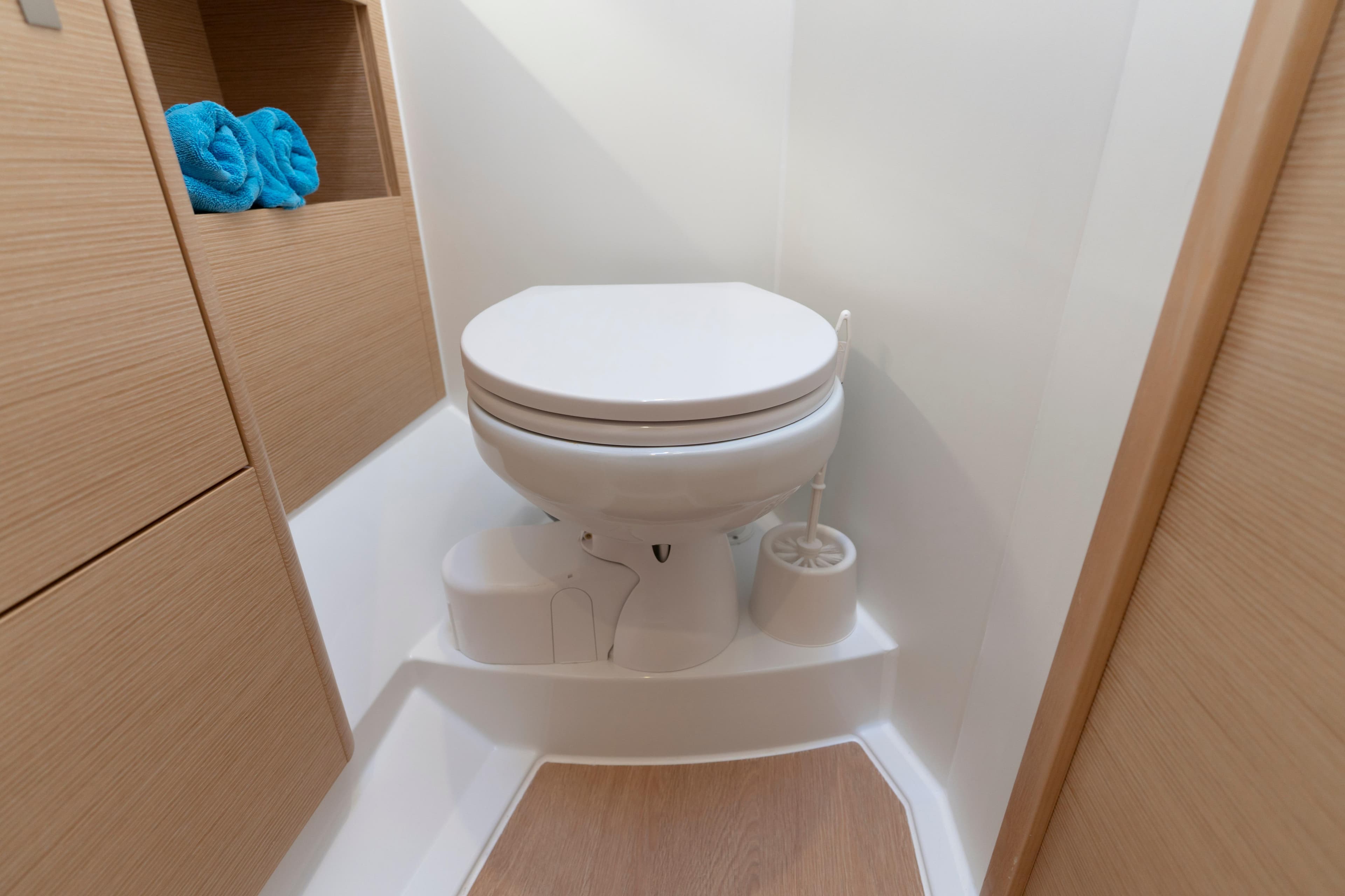 Modern bathroom in 2025 Hanse 410 yacht with wooden accents and compact toilet.