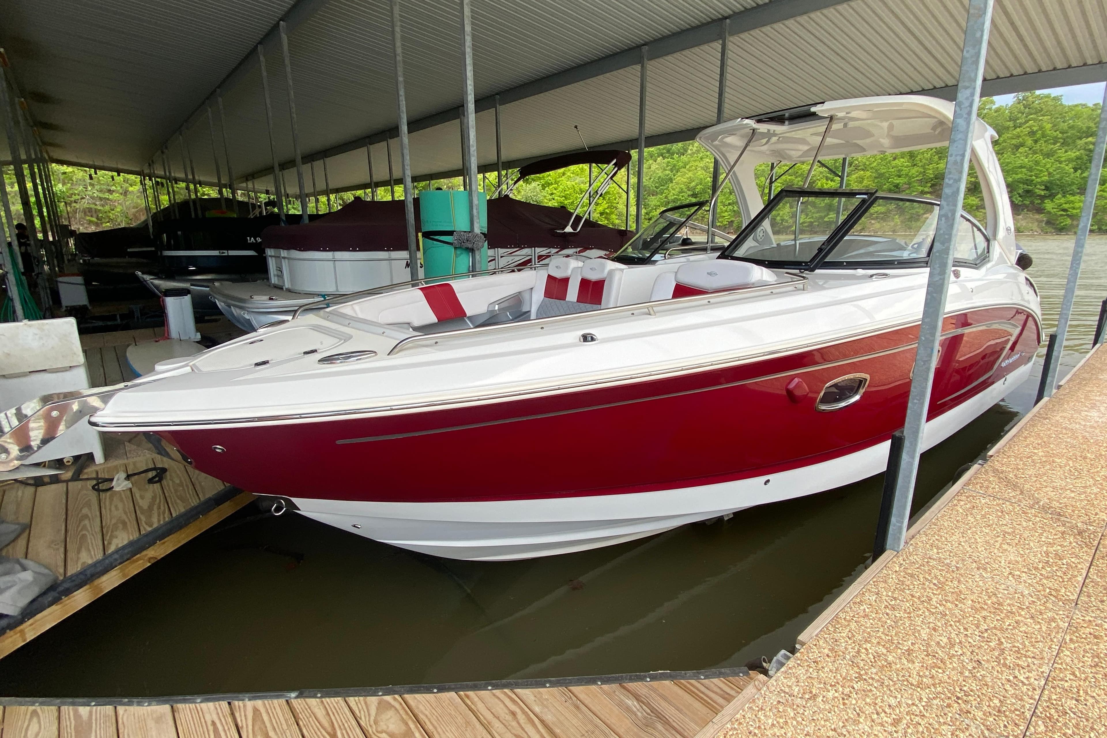 2012 Chaparral 327 SSX boat docked, featuring a sleek red and white design.