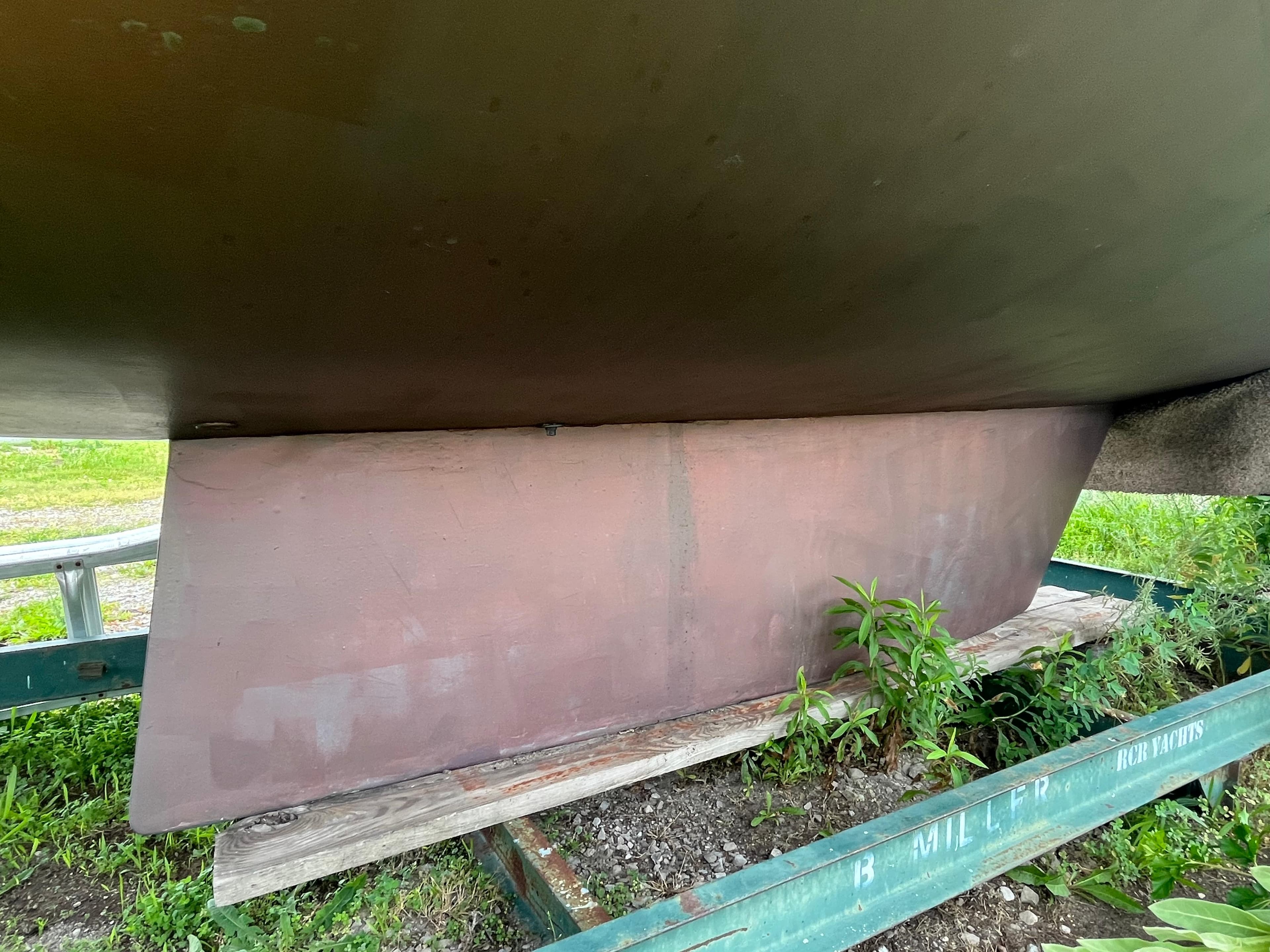1986 Pearson 33-2 sailboat keel on trailer with greenery.