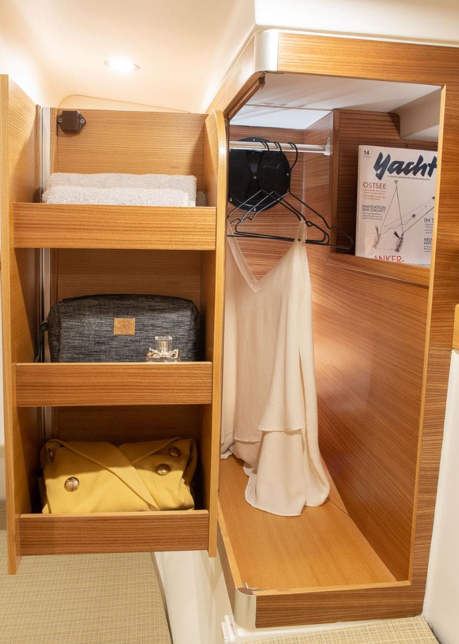 Compact wooden closet in Dragonfly 40 yacht, featuring shelves and hanging space, 2026 model.