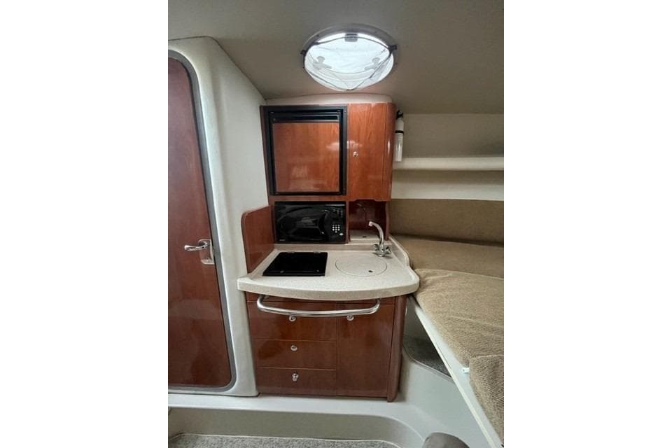 2005 Four Winns 288 Vista cabin interior with kitchenette and cozy sleeping area.