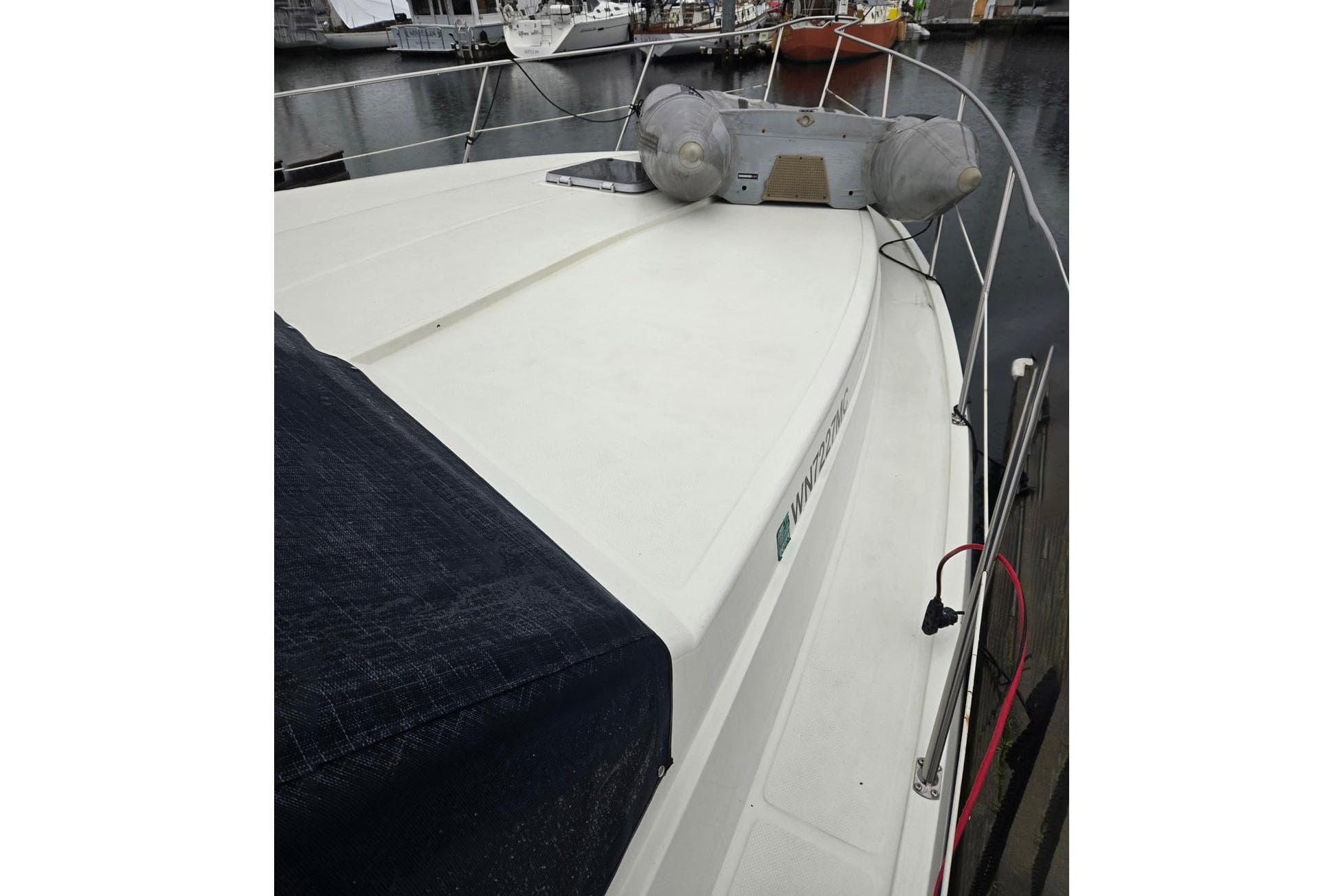 1991 Cooper Marine Prowler boat docked, featuring a spacious deck and safety railings.