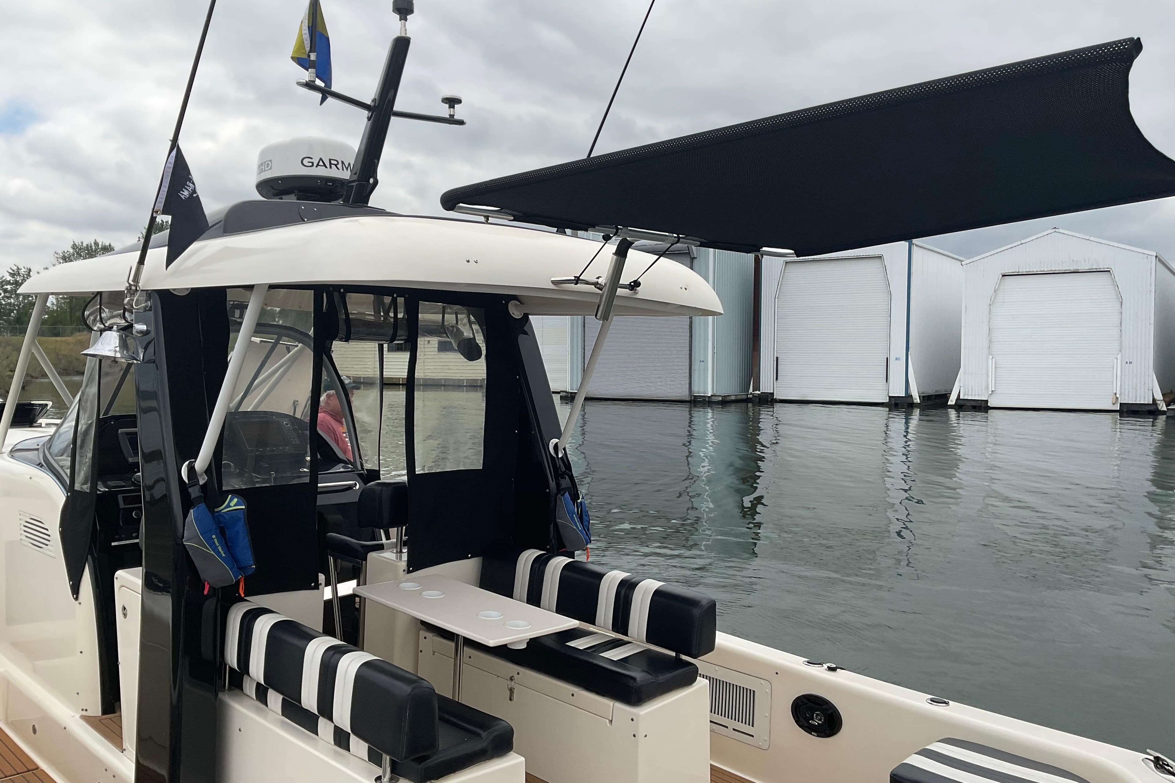 2004 Rivolta PT Runner 4.0 boat docked, featuring striped seating and a canopy.