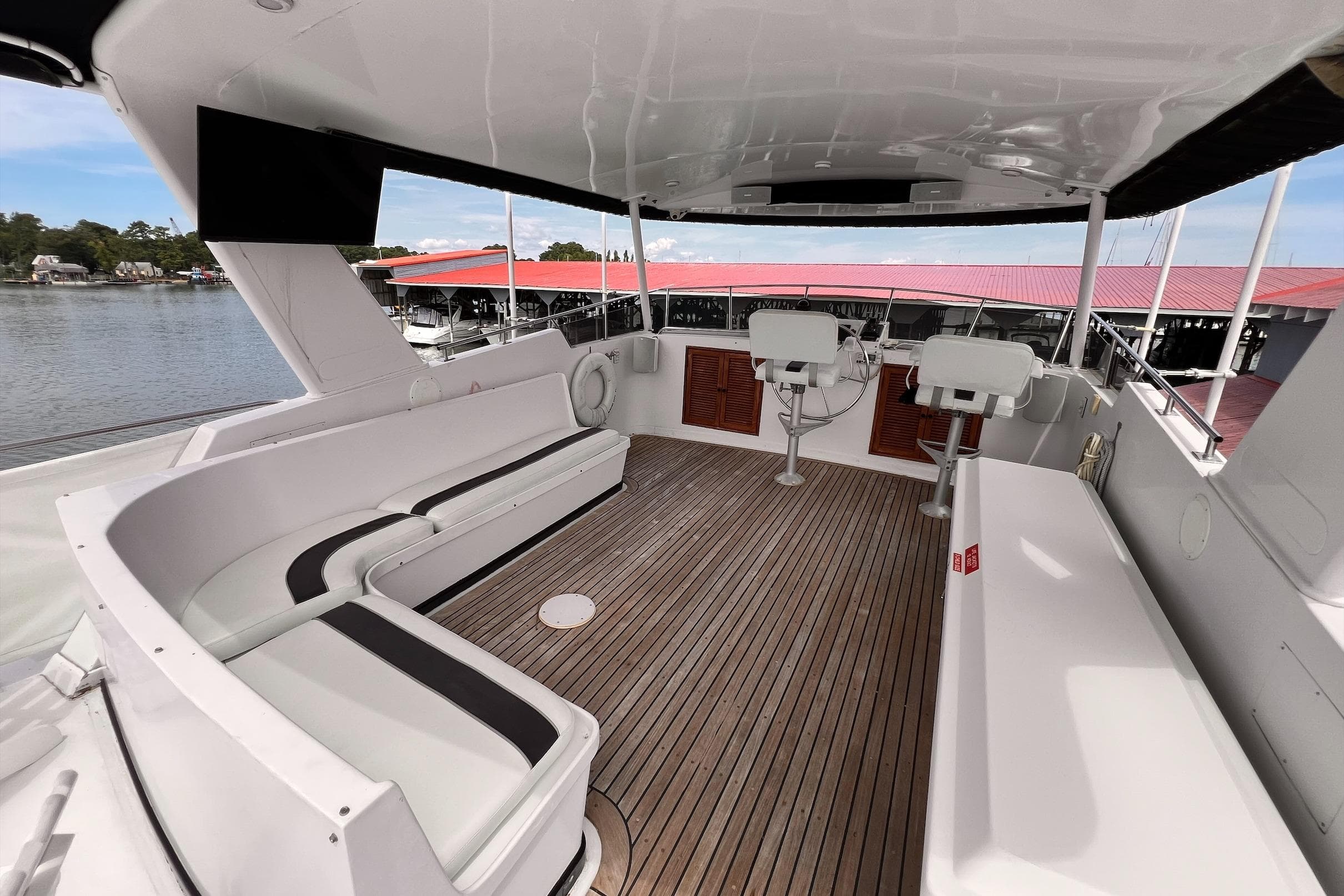 Spacious deck of 1985 Hartman-Palmer 60 Flush Deck Motor Yacht with seating and helm.