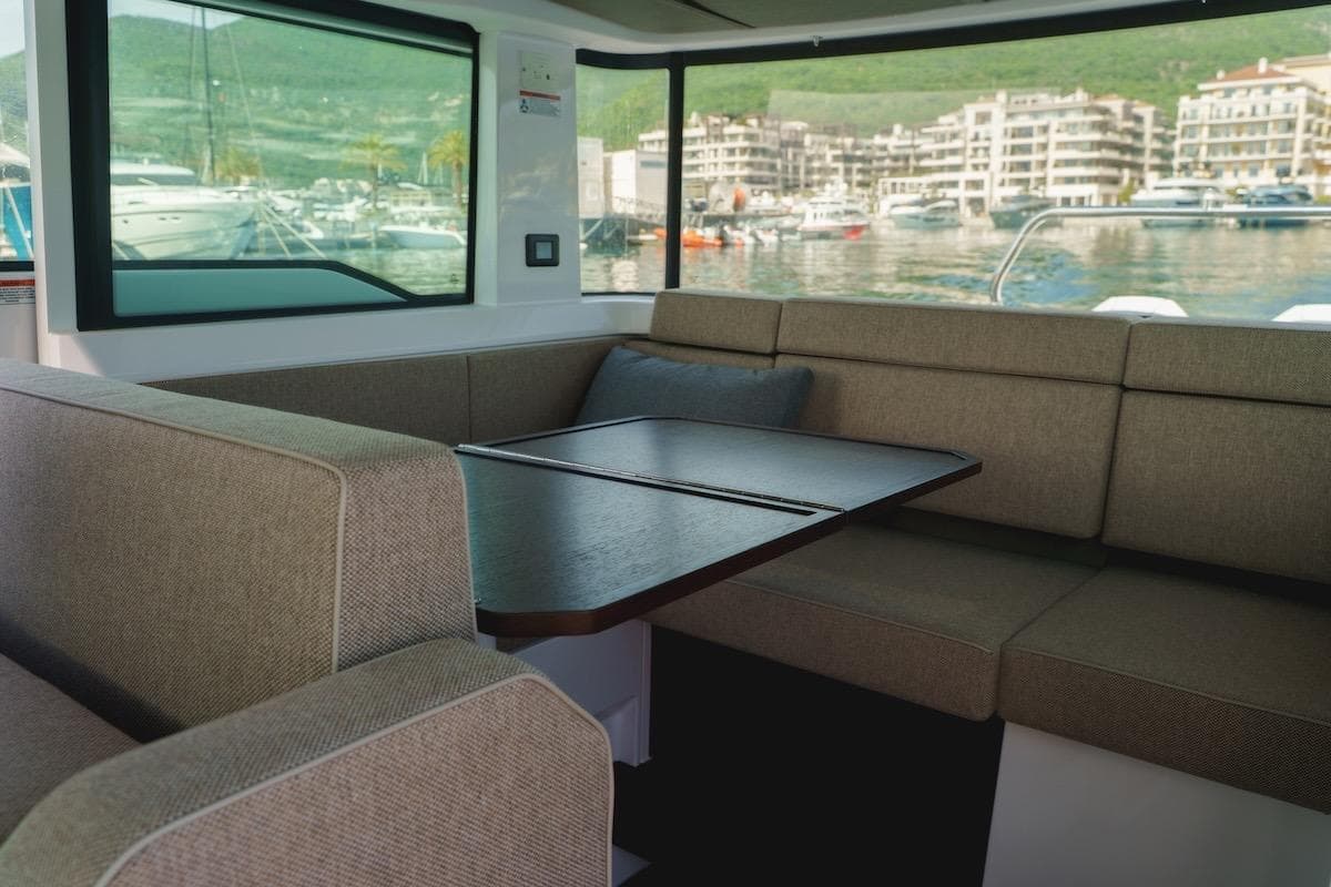 2024 Axopar 37 XC Cross Cabin interior with cozy seating and scenic marina view.