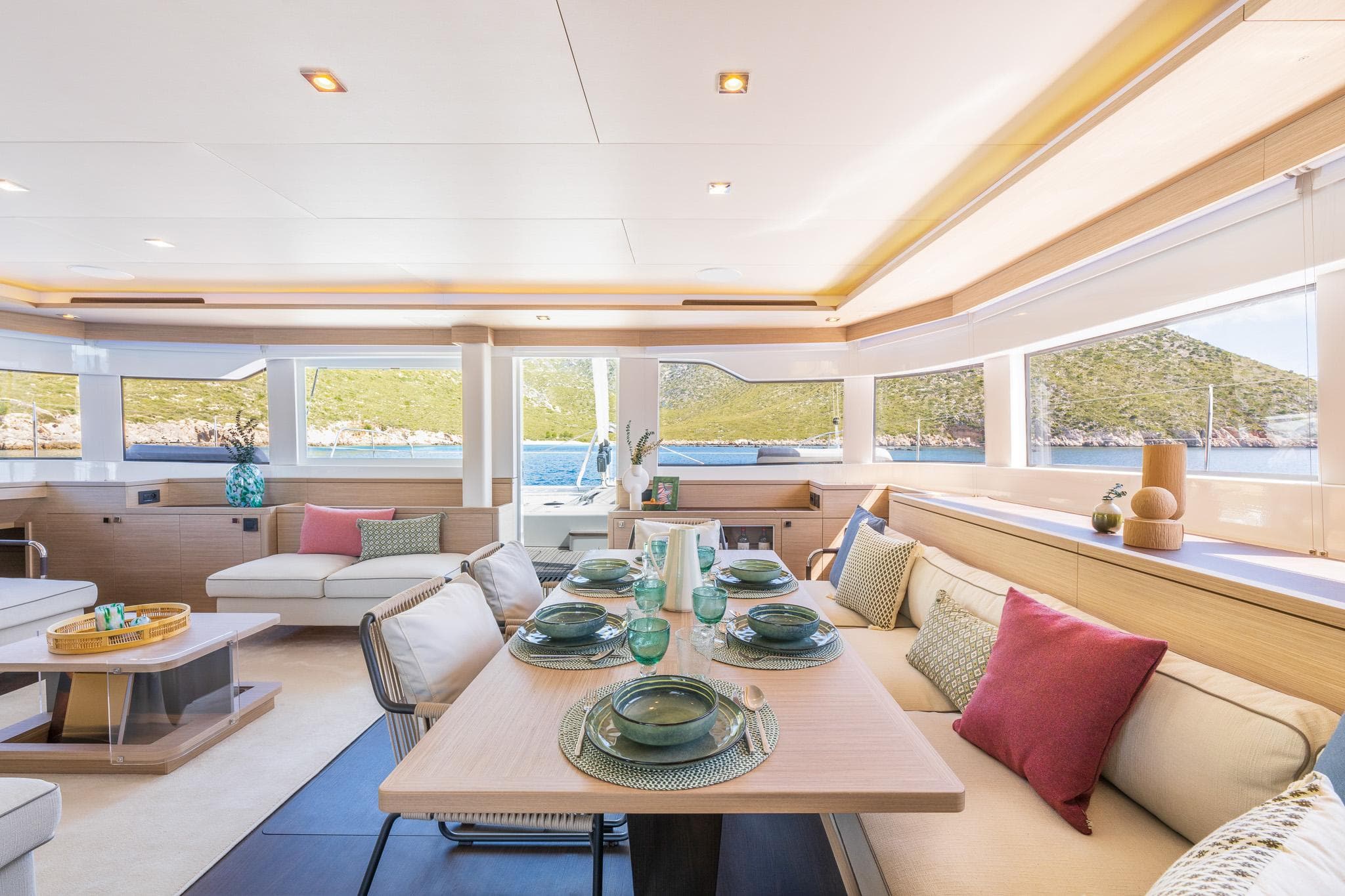 Luxurious interior of 2025 Lagoon 60 yacht with elegant dining setup and scenic views.