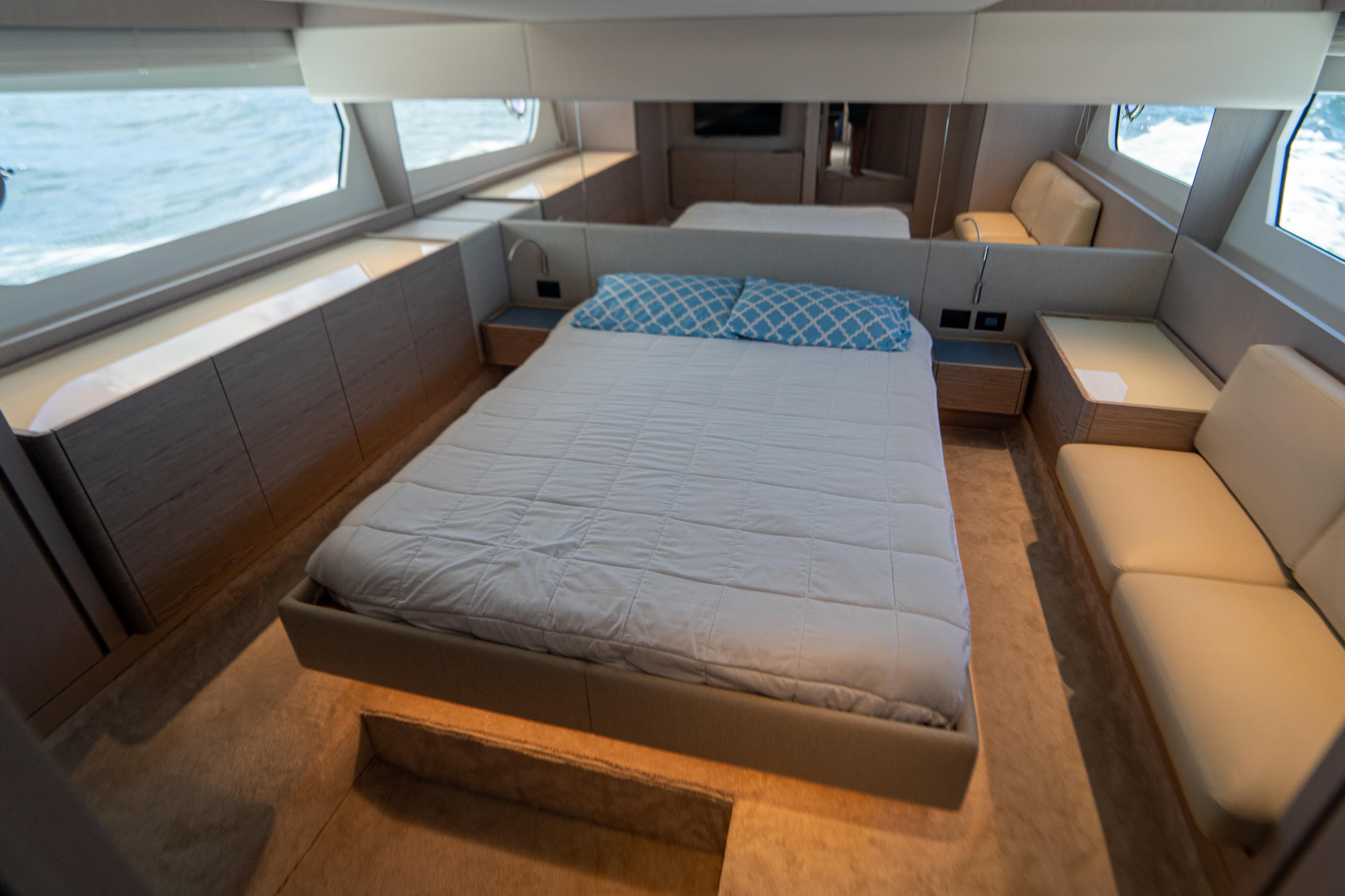 Luxurious bedroom interior of 2022 Ferretti Yachts 500 with modern design and large windows.