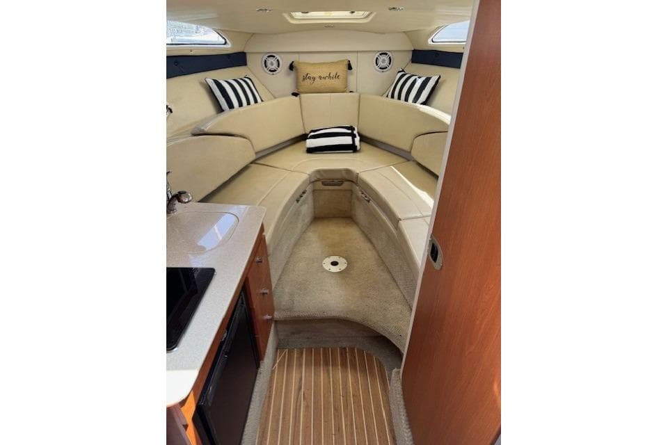 Interior of 2010 Bayliner 255 Cruiser with cozy seating and striped cushions.