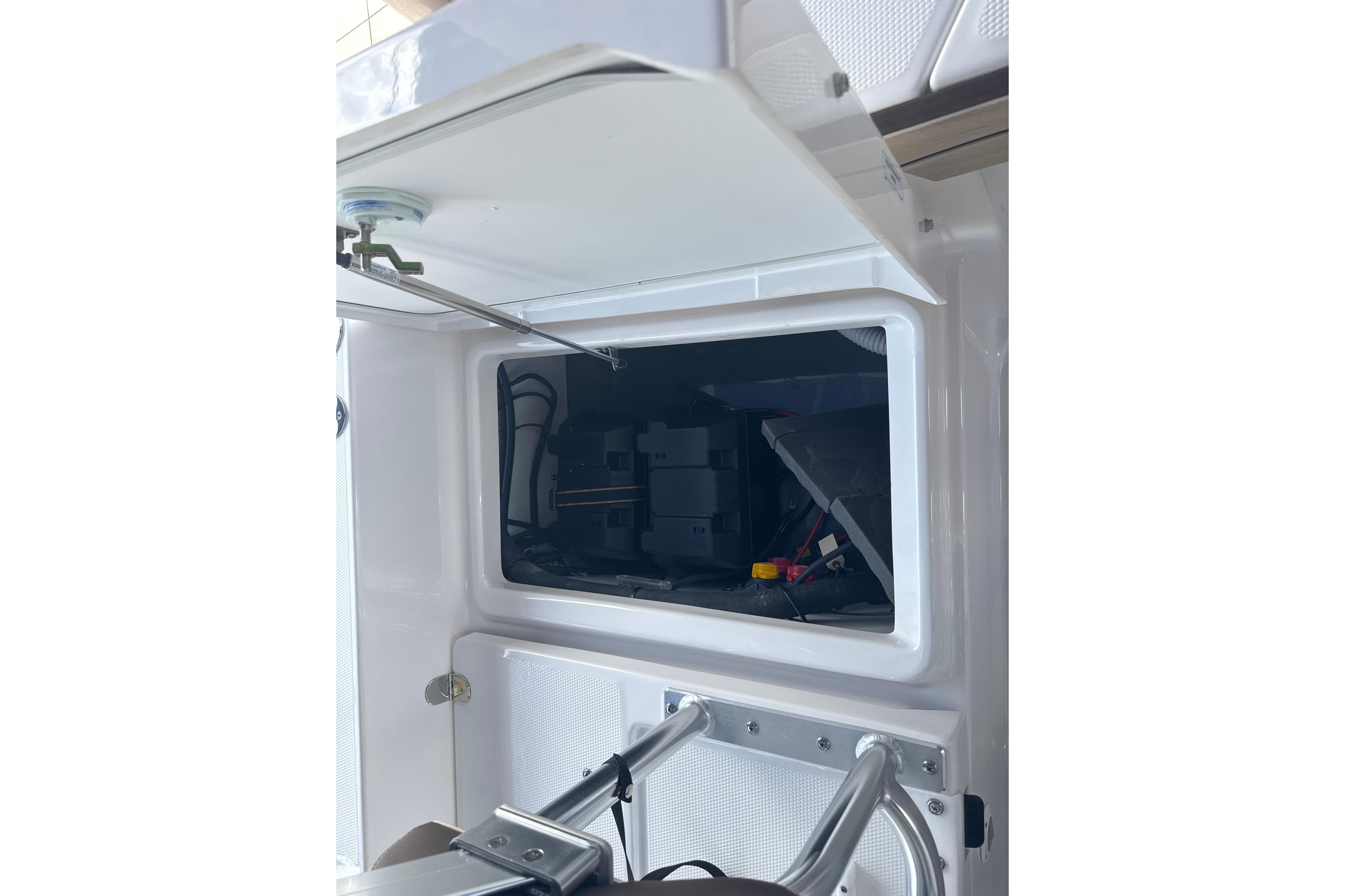 Open storage compartment on 2026 Yamaha Boats 195 FSH Sport, showcasing interior details.