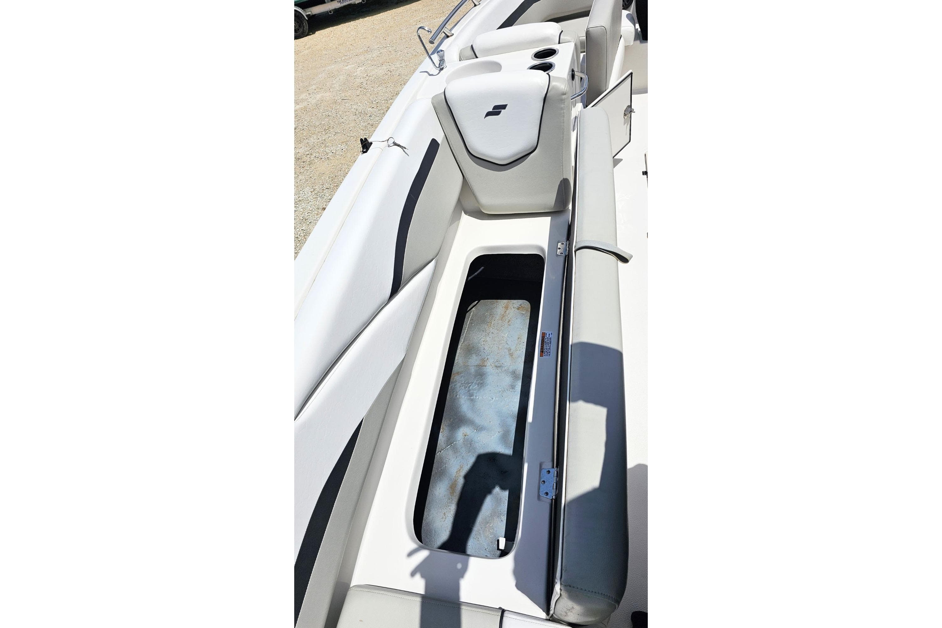 2023 Starcraft SVX 211 OB boat interior with open storage compartment and cushioned seating.