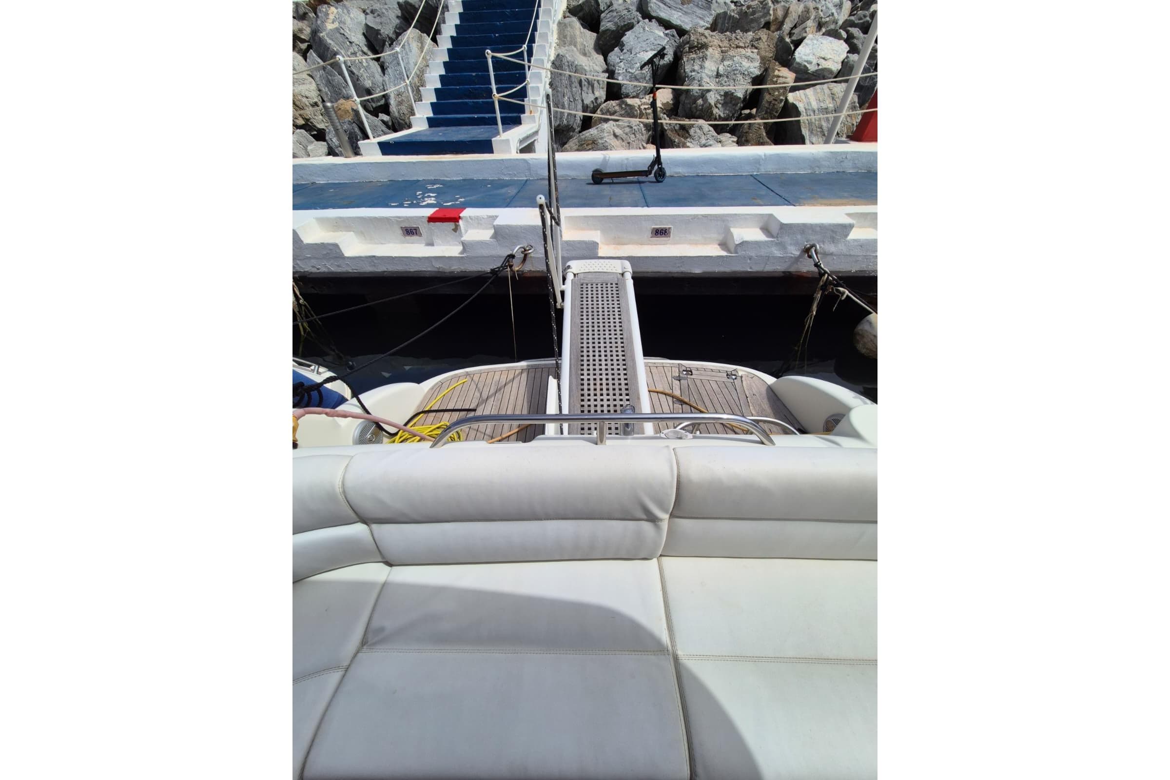 Luxury yacht Atlantis 345sc (2008) docked at marina with cushioned seating.
