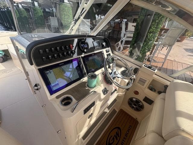 2024 Grady-White Freedom 335 boat cockpit with modern navigation equipment and steering wheel.