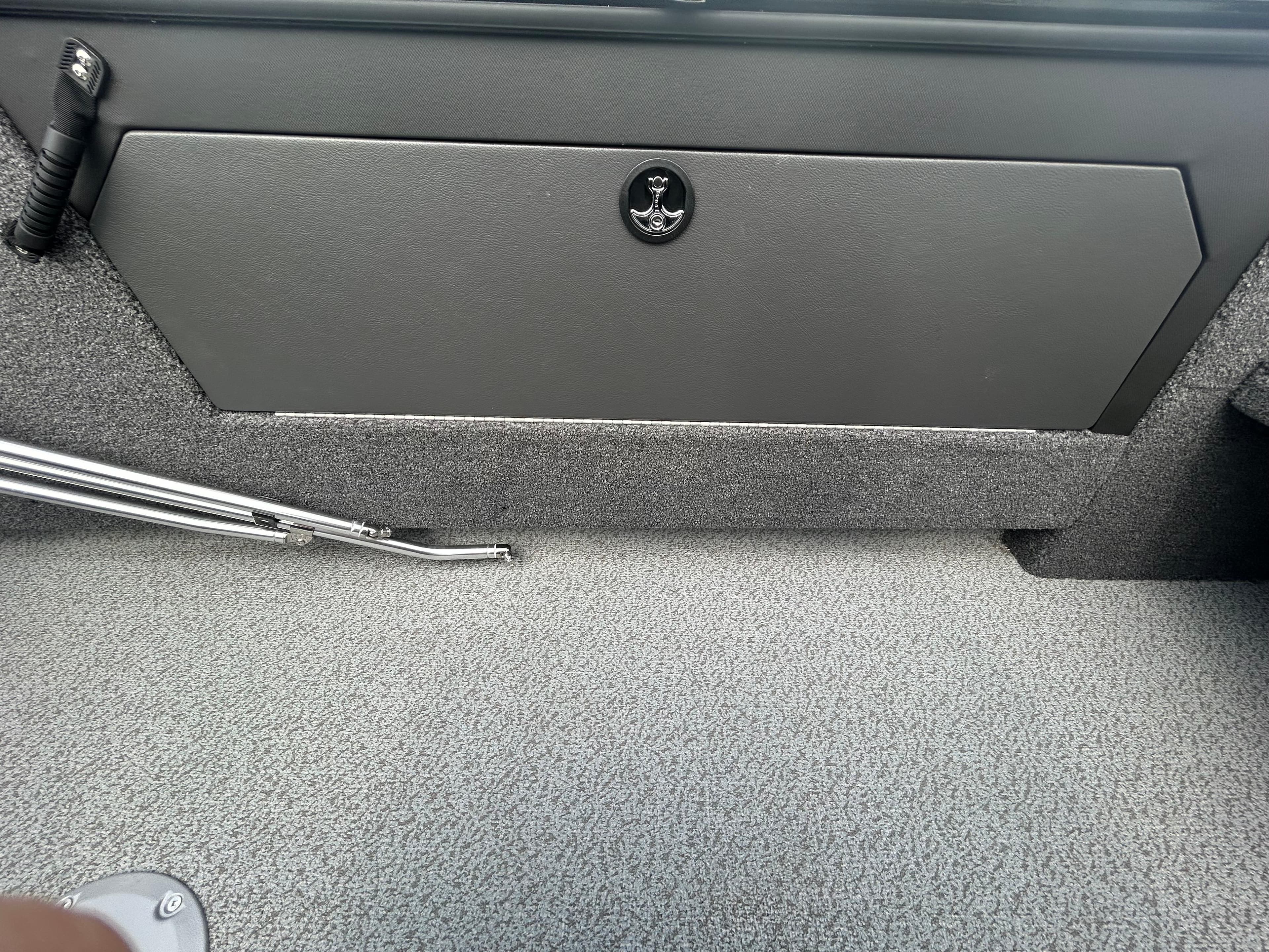 Interior of 2026 Lund 2075 Fisherman boat, featuring storage compartment and textured flooring.