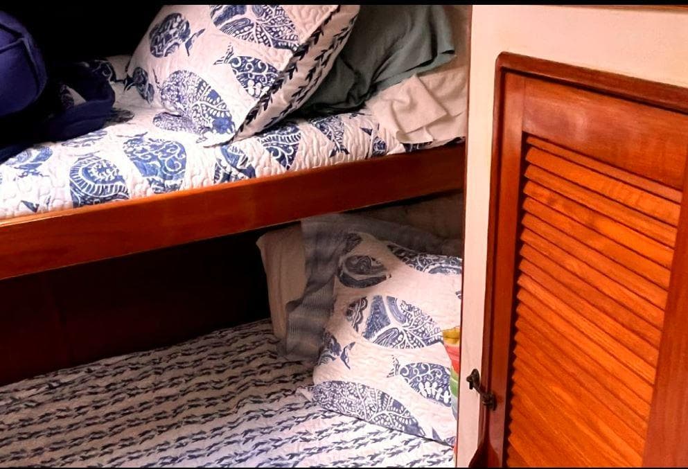 Cozy cabin bunks with nautical bedding on a 1990 Irwin 54 sailboat.