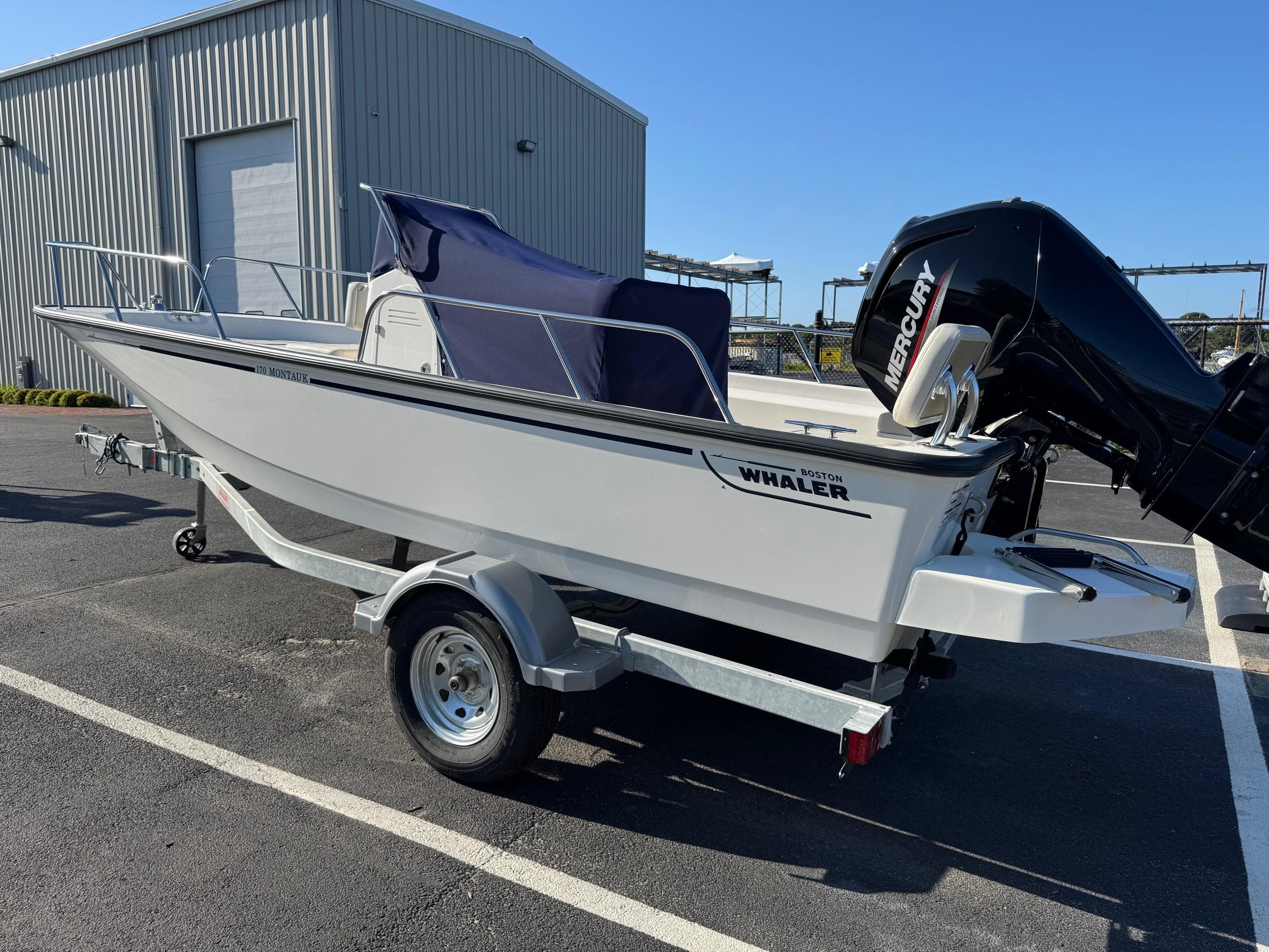 2025 Boston Whaler 170 Montauk boat on trailer, parked outdoors.