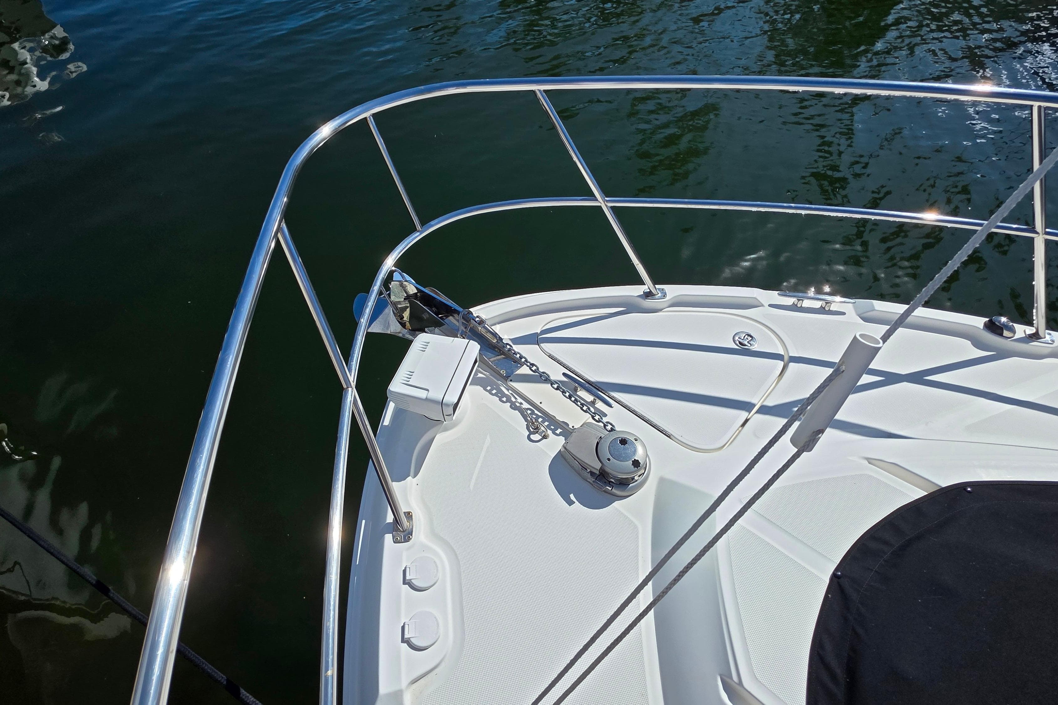 Bow of 2016 Sea Ray Sundancer 400 with anchor and railing, on calm water.