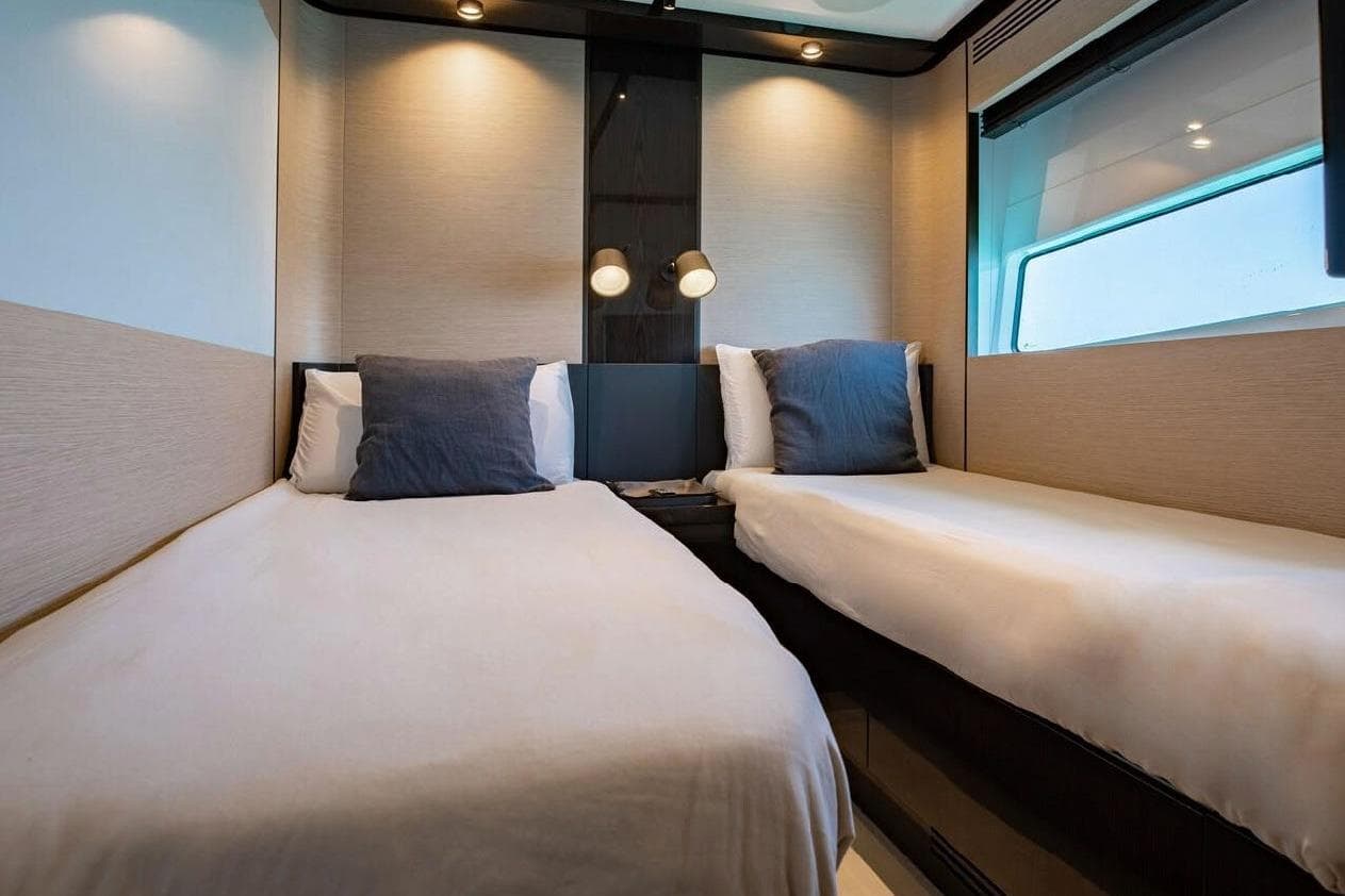Luxurious twin cabin interior on 2022 Azimut S10 yacht, featuring modern design and cozy bedding.