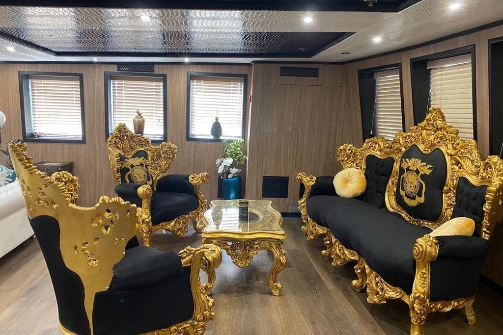 Luxurious vintage yacht interior with ornate gold and black furniture, 1954 Jadranska Linjska Plovidba.