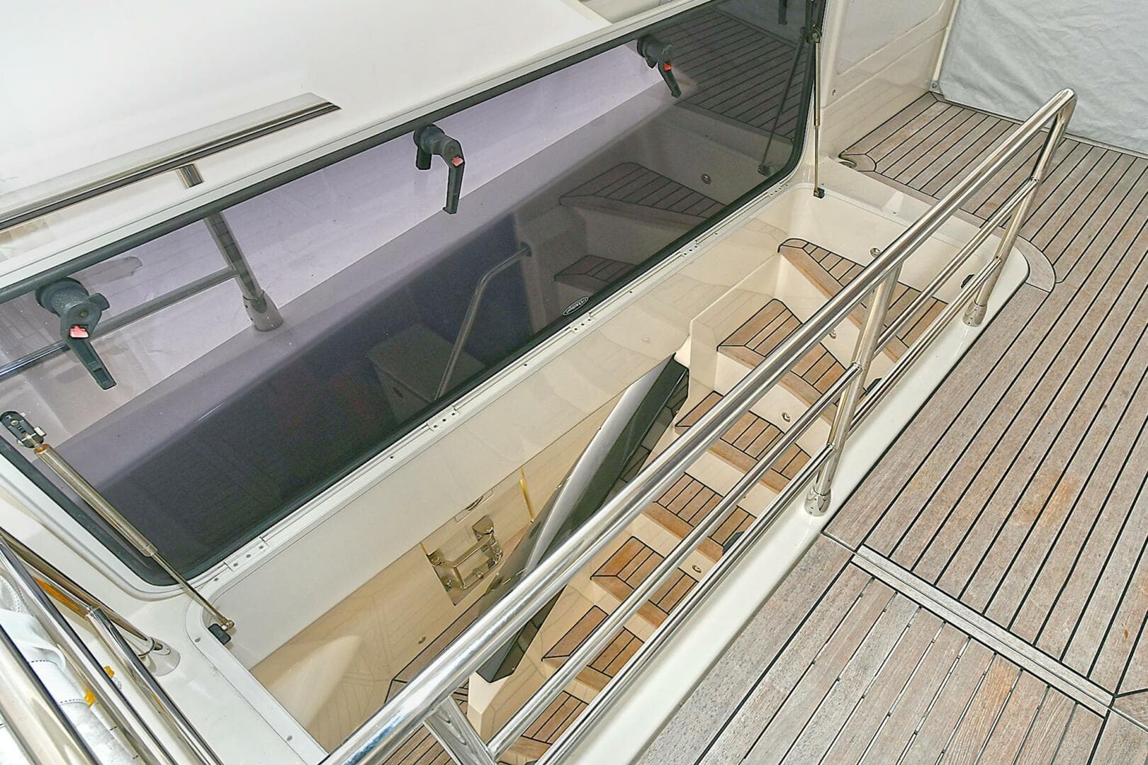 Staircase on 2022 Absolute 62 Fly yacht with wooden deck and railing.