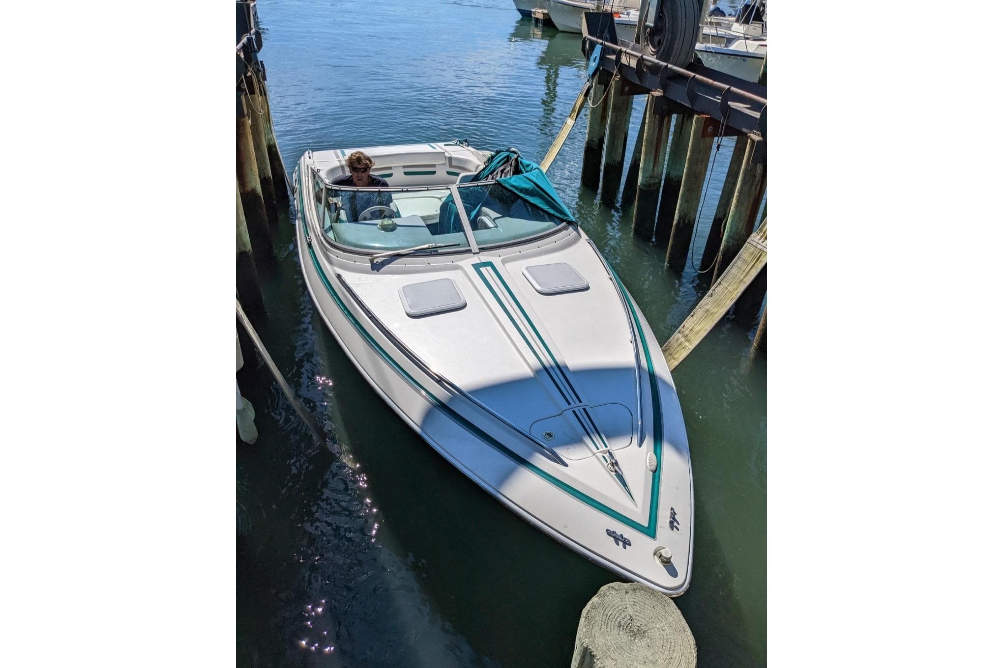 1998 Formula 252 SS boat docked in calm waters, featuring sleek design and teal accents.