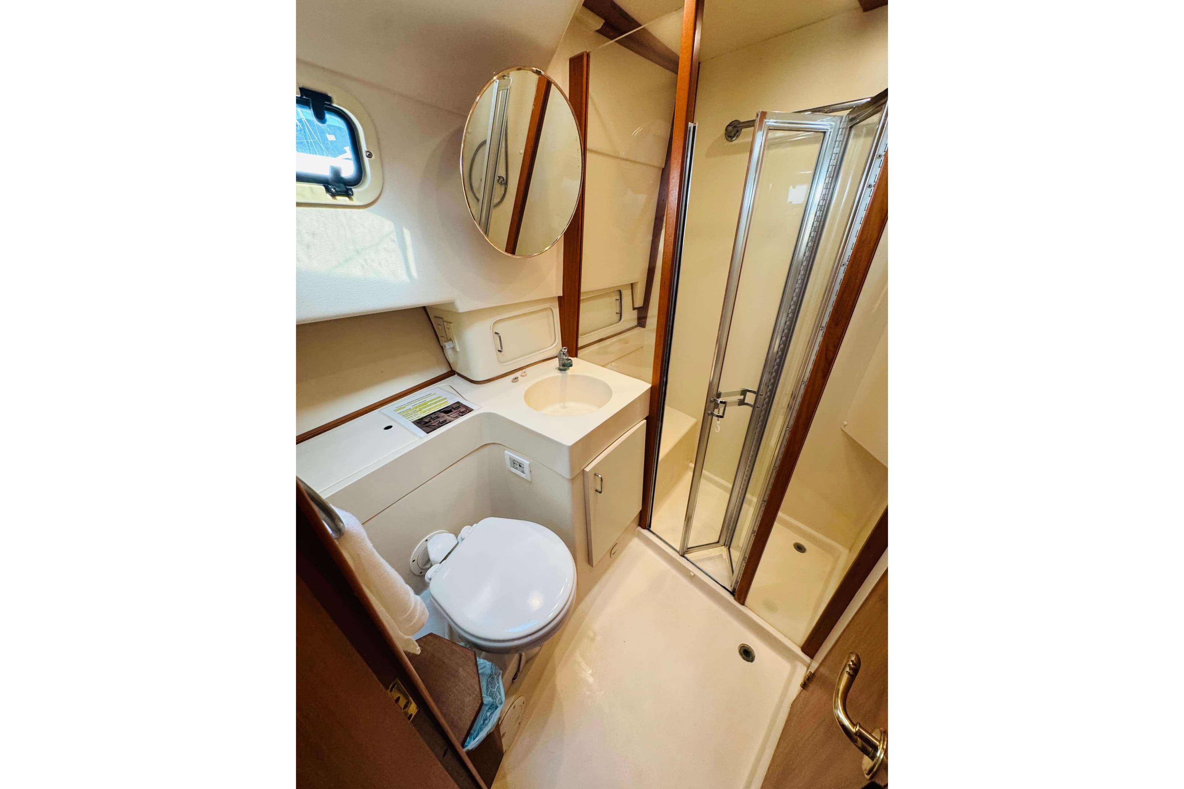 2000 Mainship 390 Trawler bathroom with shower, sink, and toilet.
