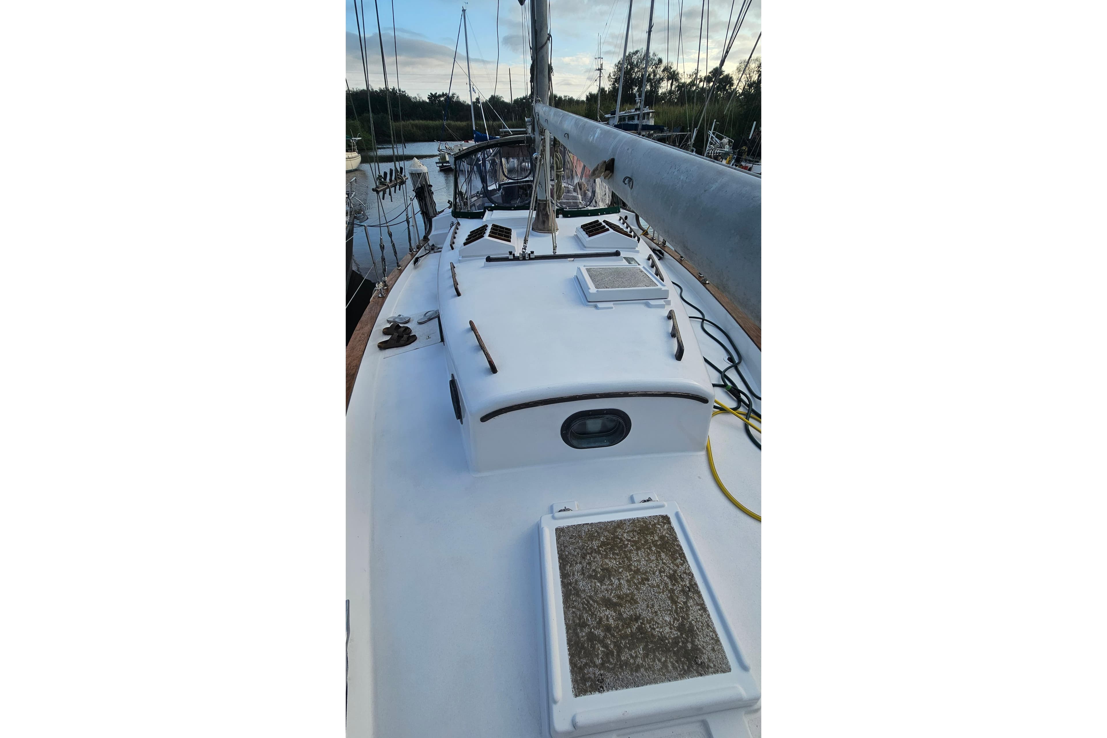 1979 CSY 44 CC sailboat deck with hatches and rigging in a marina.