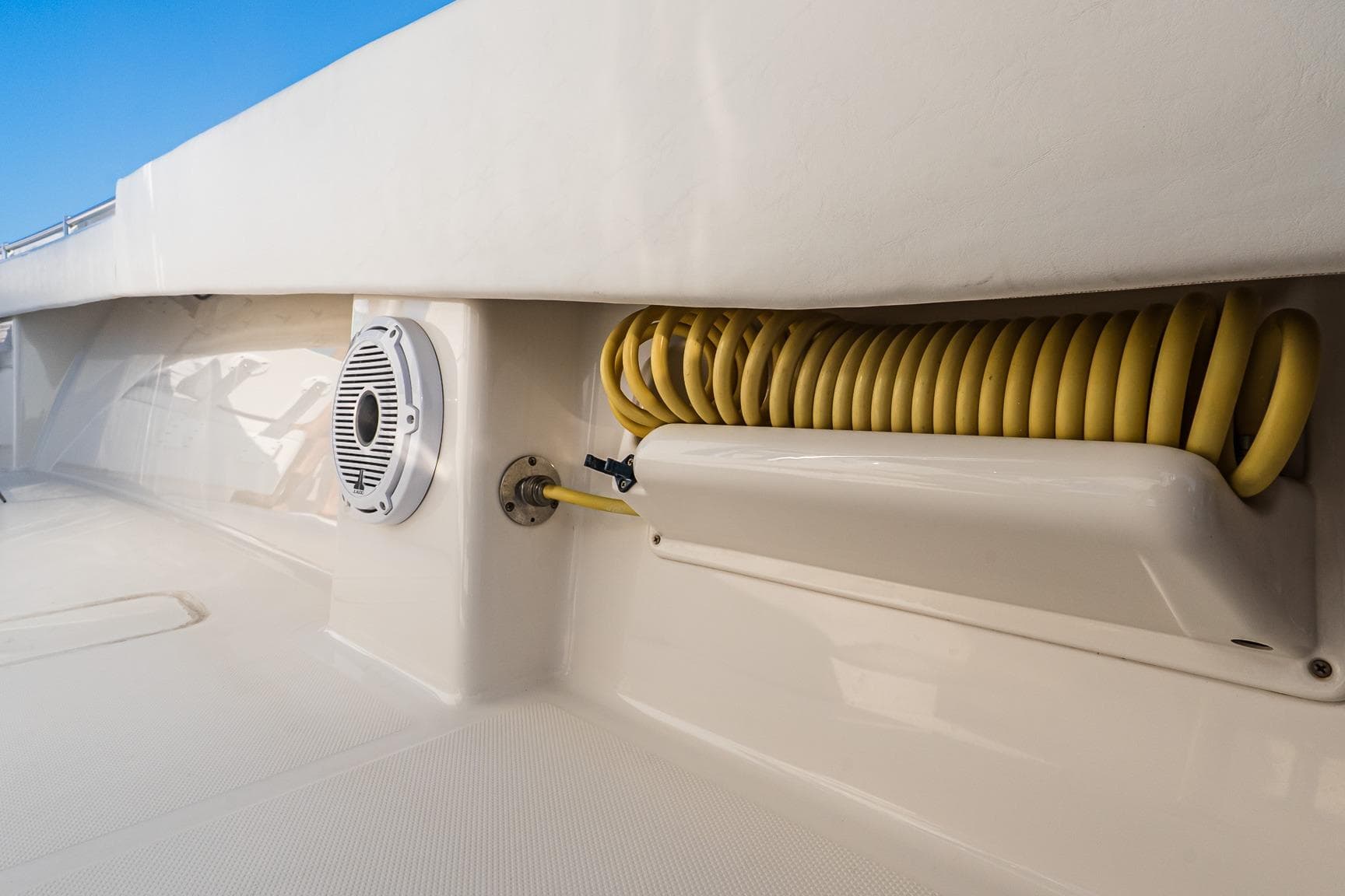 2016 Invincible 33 Open Fisherman boat deck with coiled yellow hose and speaker.