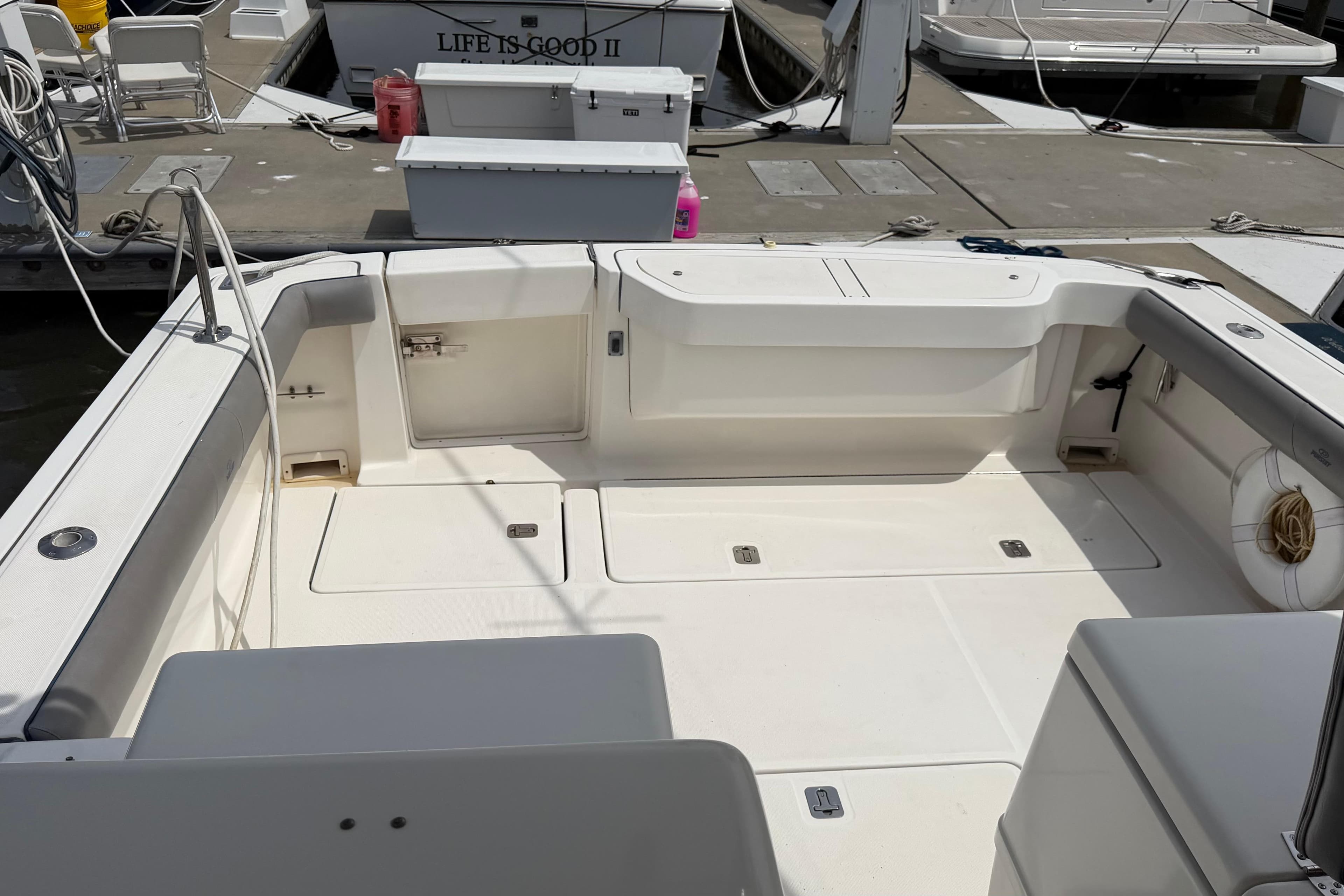 2003 Pursuit 3400 Express boat interior at dock, featuring spacious seating and storage.