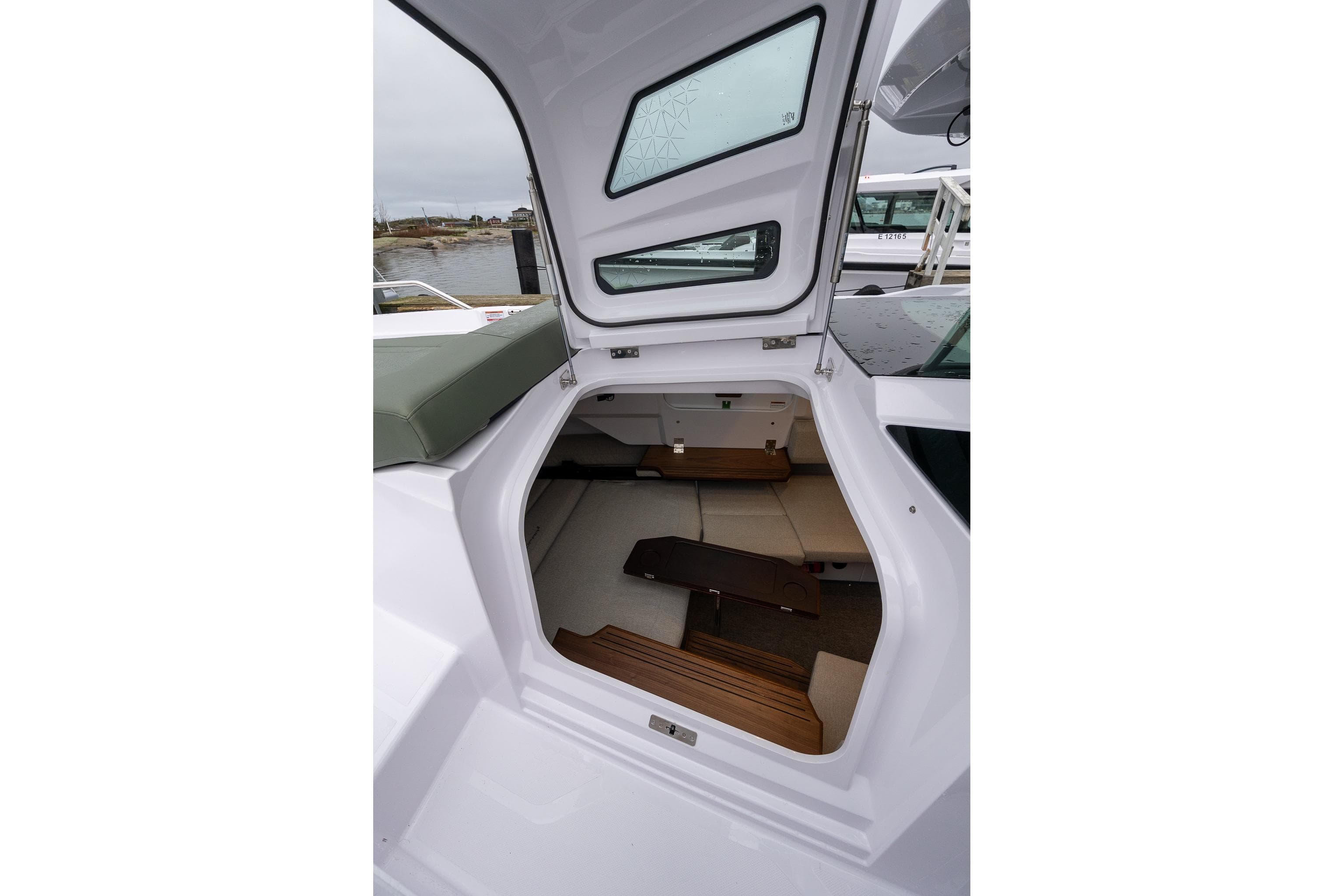 2027 Axopar 38 Cross Cabin interior view with seating and wooden flooring.